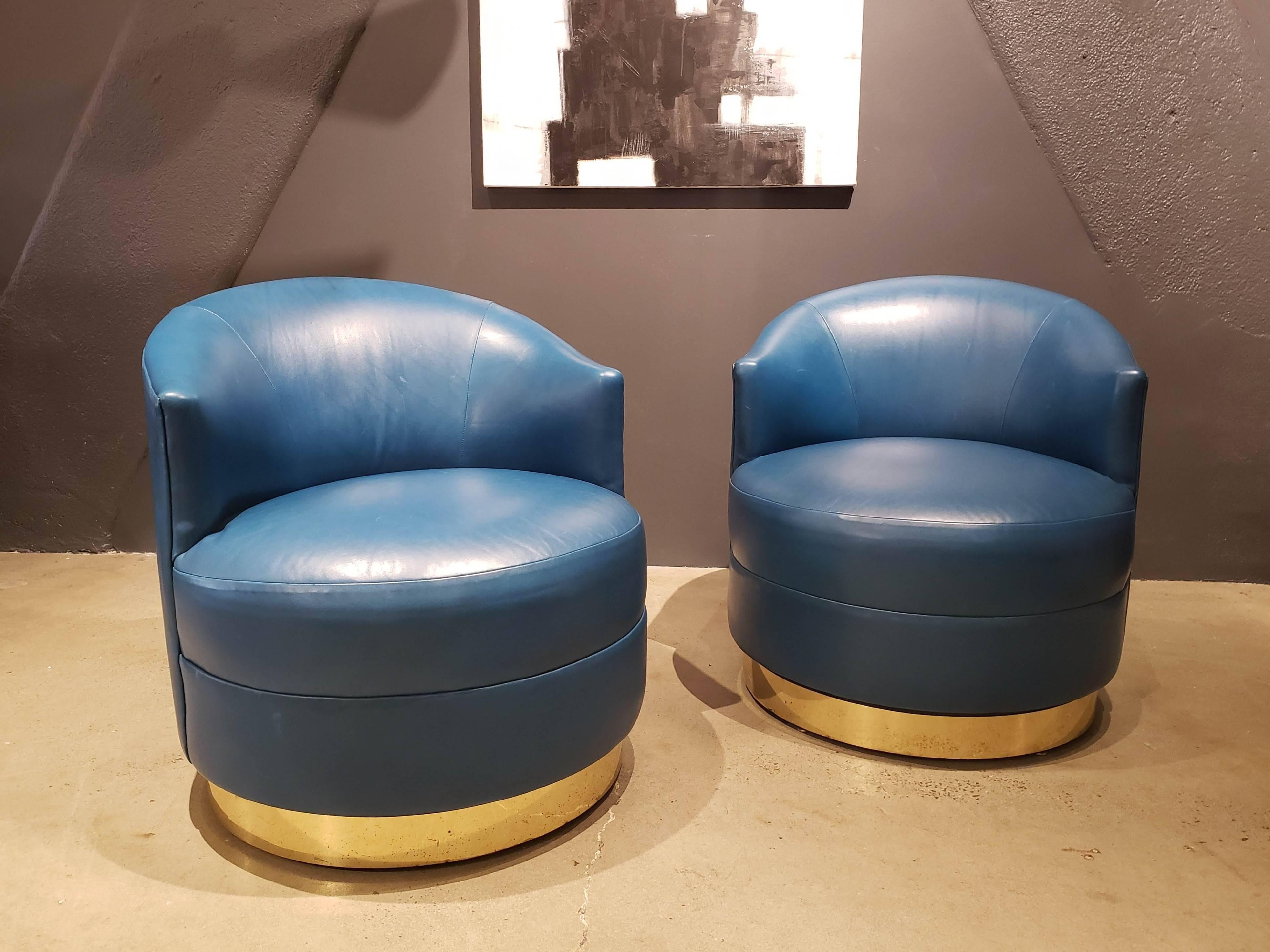 Stunning pair of swivel chairs with brass bases designed by Karl Springer, circa 1980. These are in the original buttery soft teal or cyan leather--the color is so rich and regal. Comfortable and stout and a handsome design statement. Brass bases