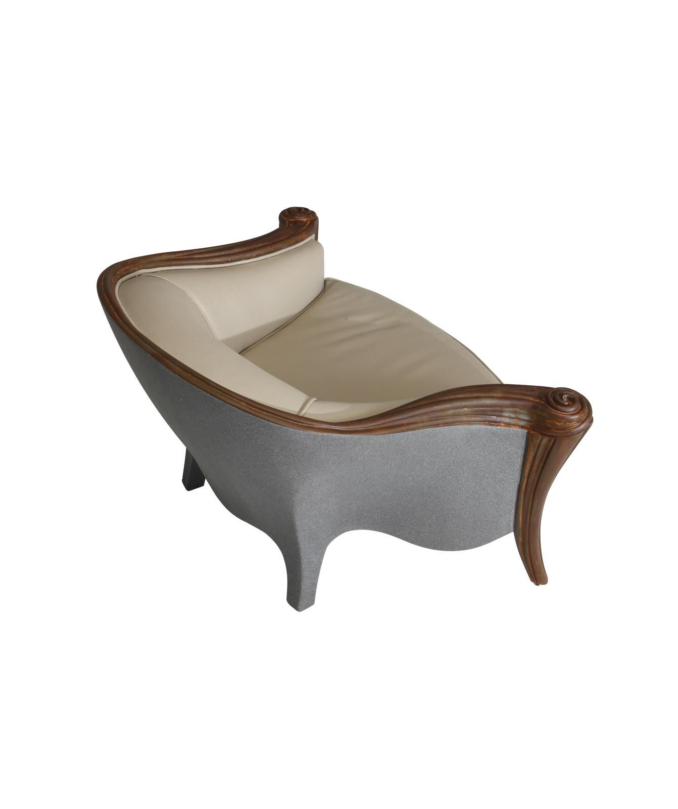 This elegant armchair, designed for children or pets, evokes the glamour of the Classic tub-bergère style, reinterpreted using modern materials. The wooden frame features exquisitely carved front legs with a brown Corten finish that extend into the