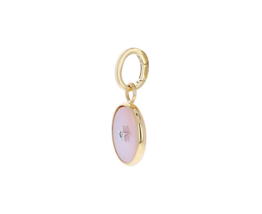 Mini Pale Pink Mother-of-Pearl Ora Pure 18kt yellow Charm Pendant - with 1 openable clasp.
The pink mother-of-pearl is set in a bezel of 18K yellow gold and has a tiny 18K white gold star diamond at its center.  
The 18K yellow gold charm hangs from