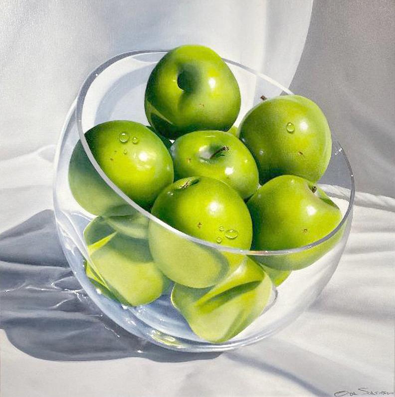Questo pezzo, "Mele e Cristallo", dell'artista Ora Sorensen è un dipinto a olio su tela 30x30 raffigurante una ciotola di mele verdi e croccanti in un piatto di cristallo, circondato da un panno bianco che fa da sfondo. La luce si riflette