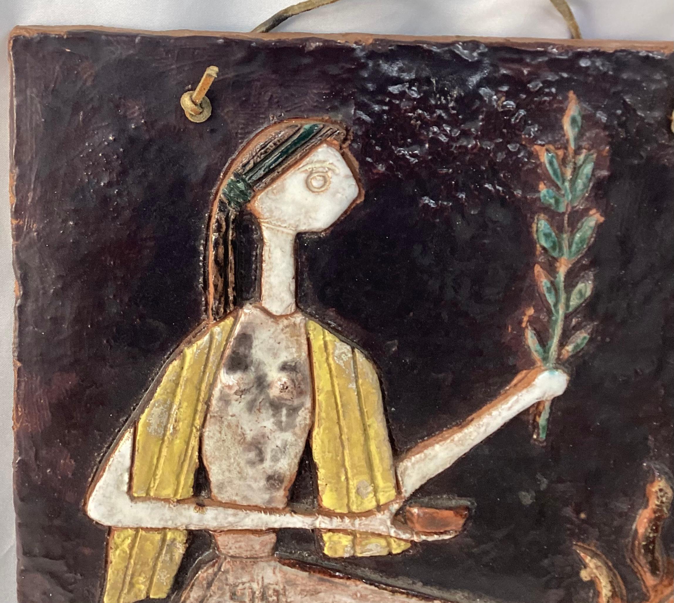 Unique ceramic art plaque of The Oracle of Delphi. The ceramic has a leather hanger at top to hang on wall. Contains colors of yellow, green and brown The Oracle of Delphi was a priestess who sat on a three-legged bronze bowl . She was known for