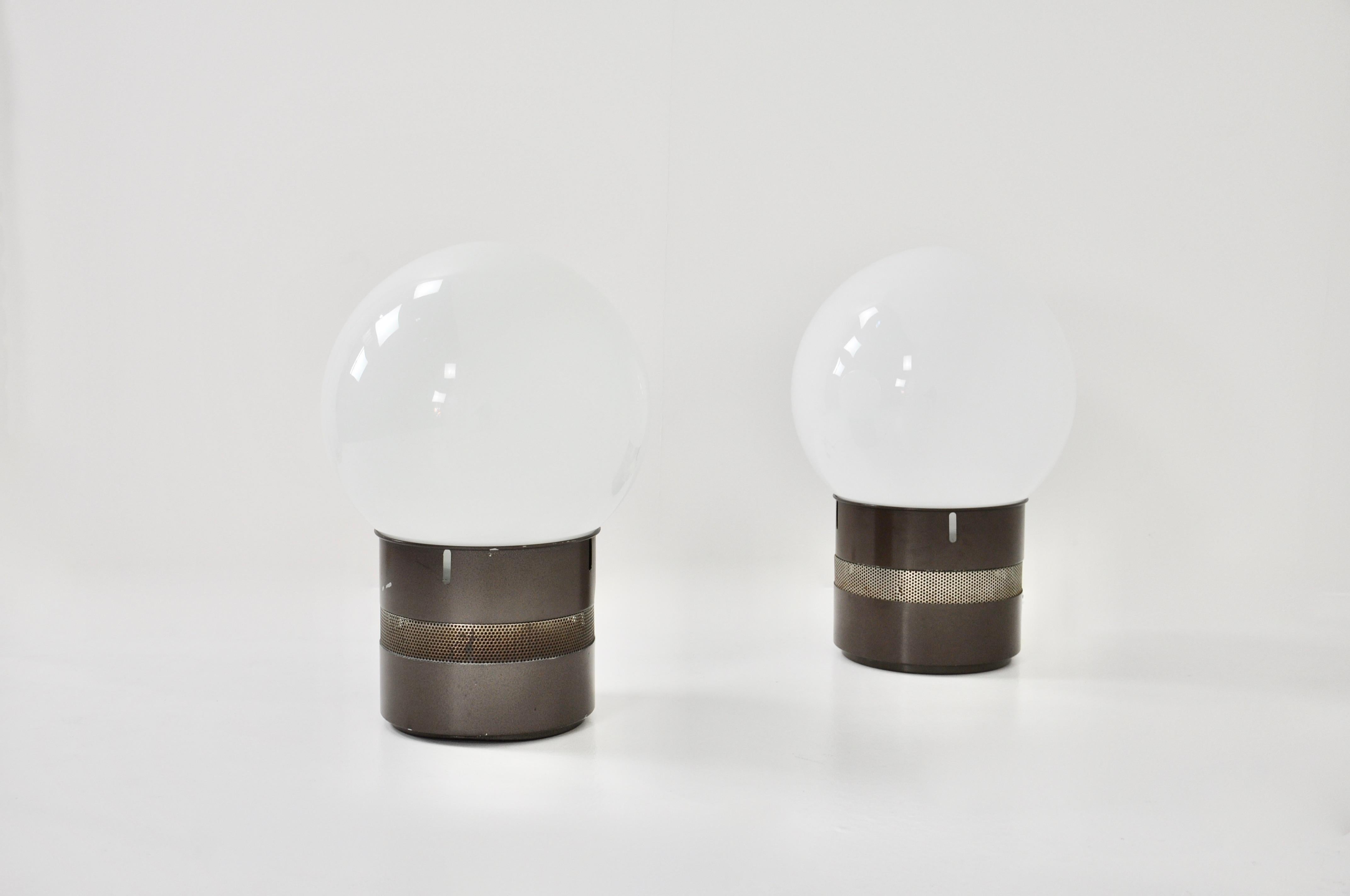 Pair of metal lamps with Oracle glass ball by Gae Aulenti. Wear due to time and age of the lamp.