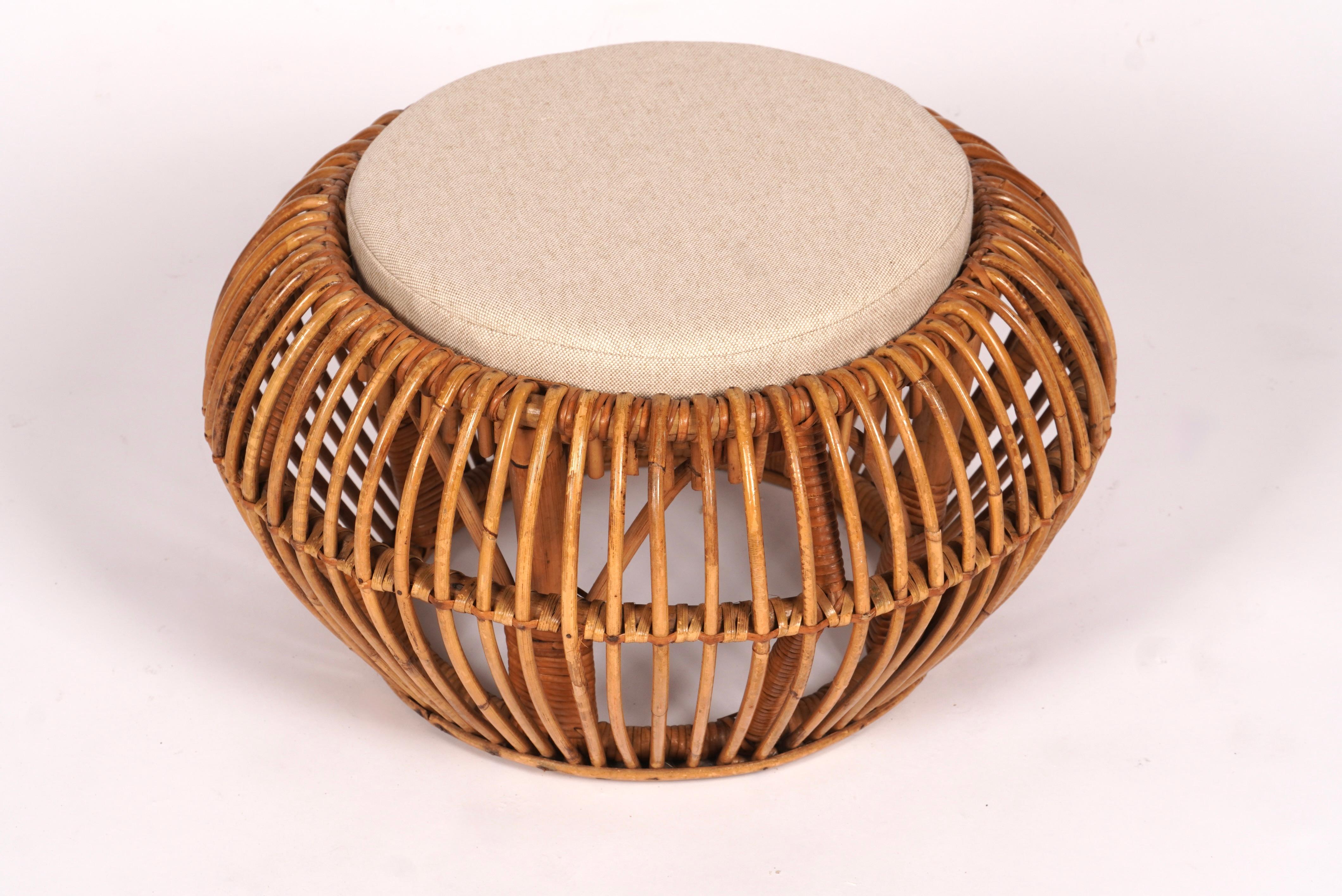 Rattan ottoman / pouf with upholstered cushion insert. The ottoman has a wonderful architectural quality to with its array of constrction details. Golden tones to the rattan from age.