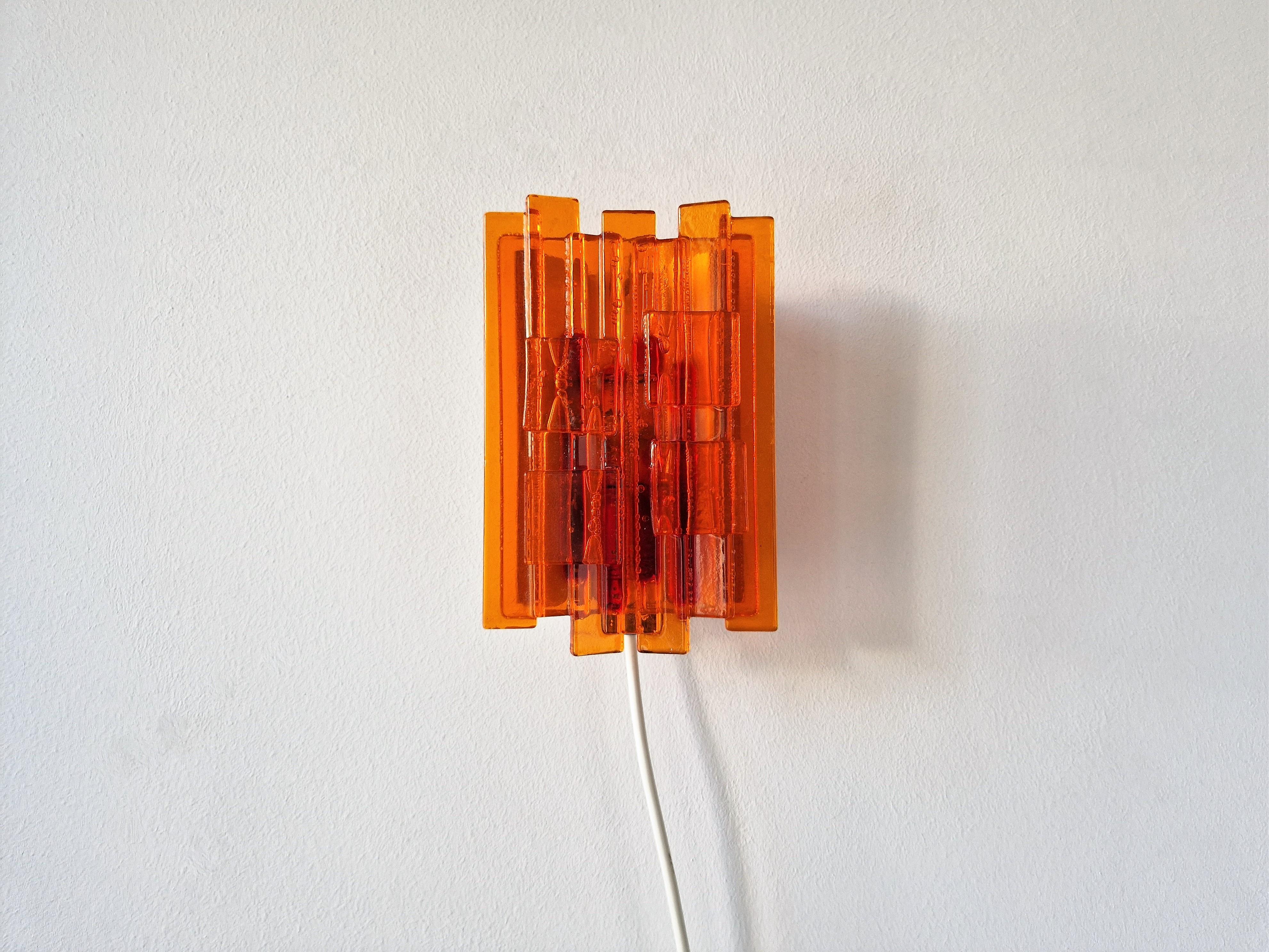 This stunning handmade wall lamp was designed by Claus Bolby and manufactured by his own company Cebo Industri in Denmark. It is made of acrylics, a material that Claus Bolby experimented with in the 1960's, to make all kinds of shapes and forms. A