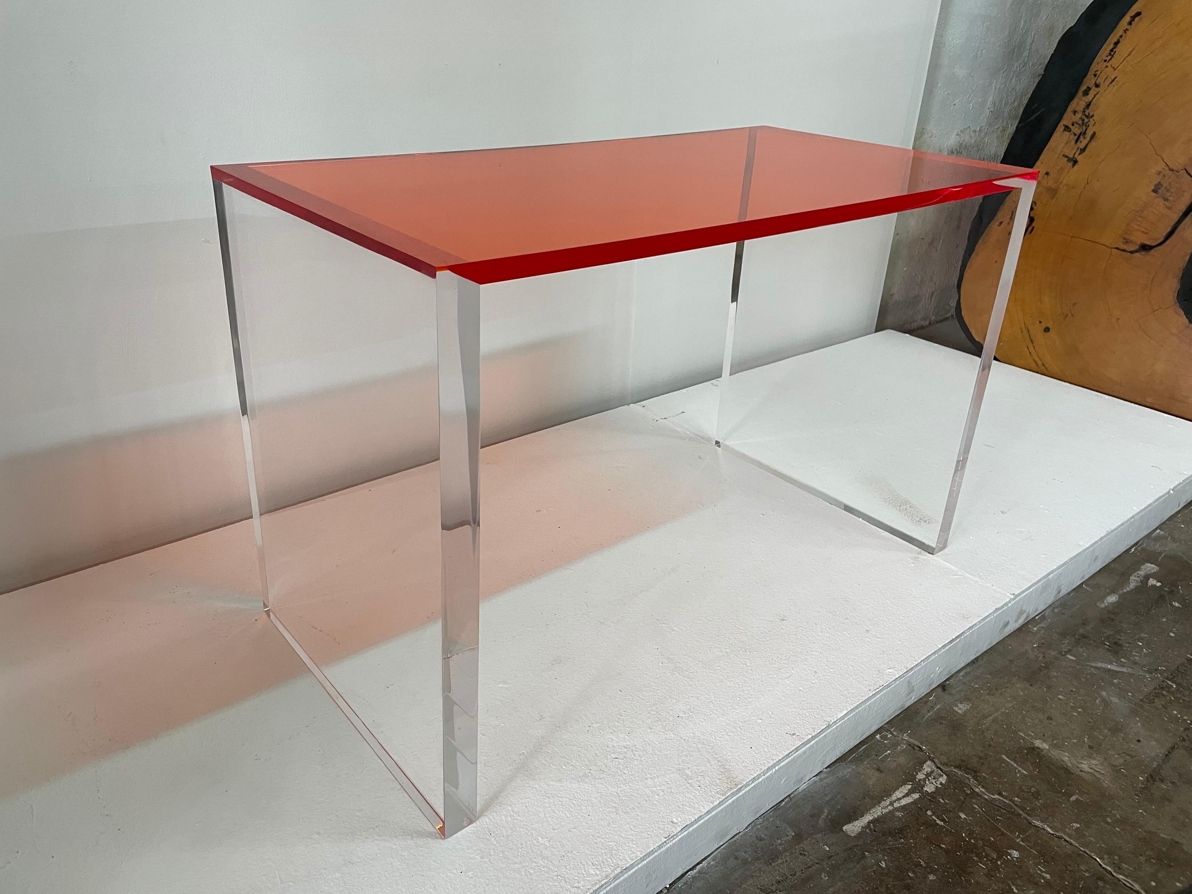 This waterfall design all acrylic desk or game table has perfect lines and scale, heavy and perfect for any space. The top is a VIVID orange and the side panels are 2 inches thick clear acrylic.
