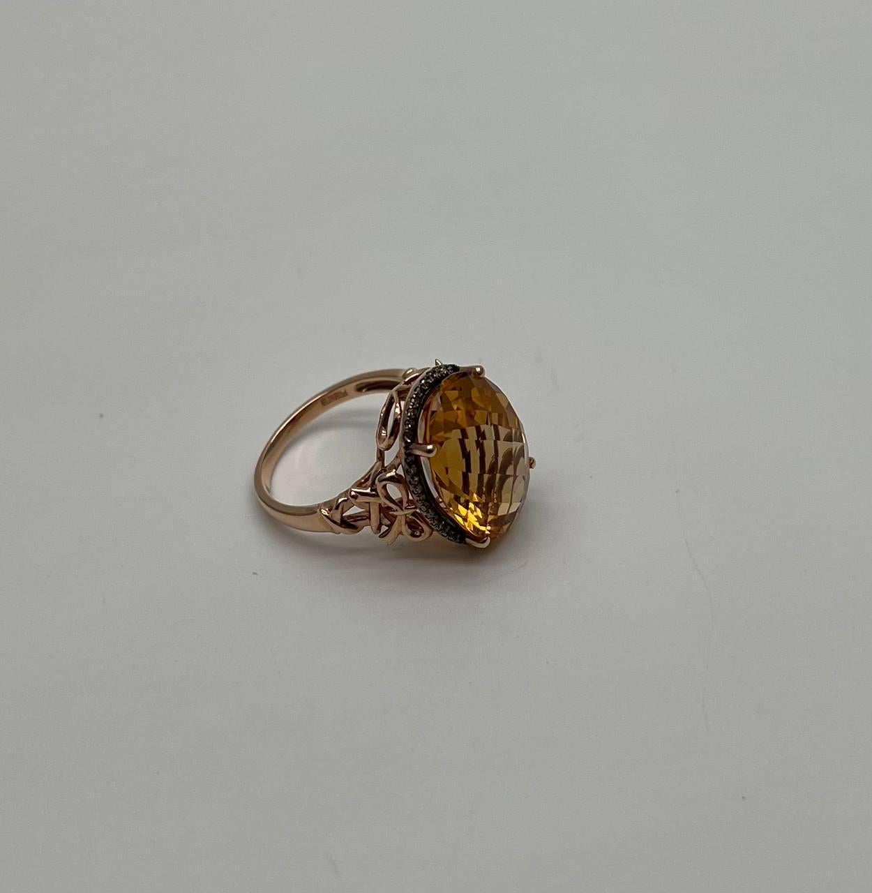 This captivating piece features a large, faceted oval citrine in a warm golden hue, set in a delicate rose gold band. The intricate setting enhances the stone's brilliance, creating a harmonious blend of color and light.
The ring's design showcases