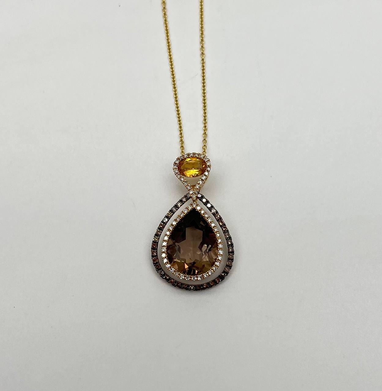 It features a teardrop-shaped pendant with a large, faceted brown smoky quartz at its center. Surrounding the gemstone are two rows of small, sparkling diamonds, creating a layered effect. Above the teardrop, a smaller round orange citrine is set,
