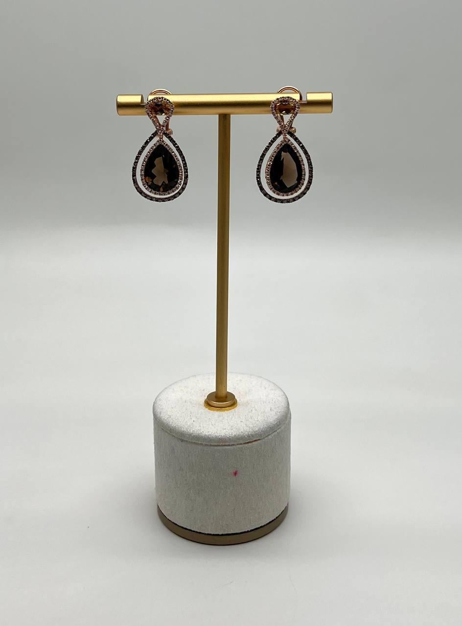 Enhance your elegance with these stunning earrings. Crafted with precision, the earrings feature a captivating teardrop design, showcasing a rich, dark brown smoky quartz and orange citrines encircled by delicate, shimmering accents. Sophisticated