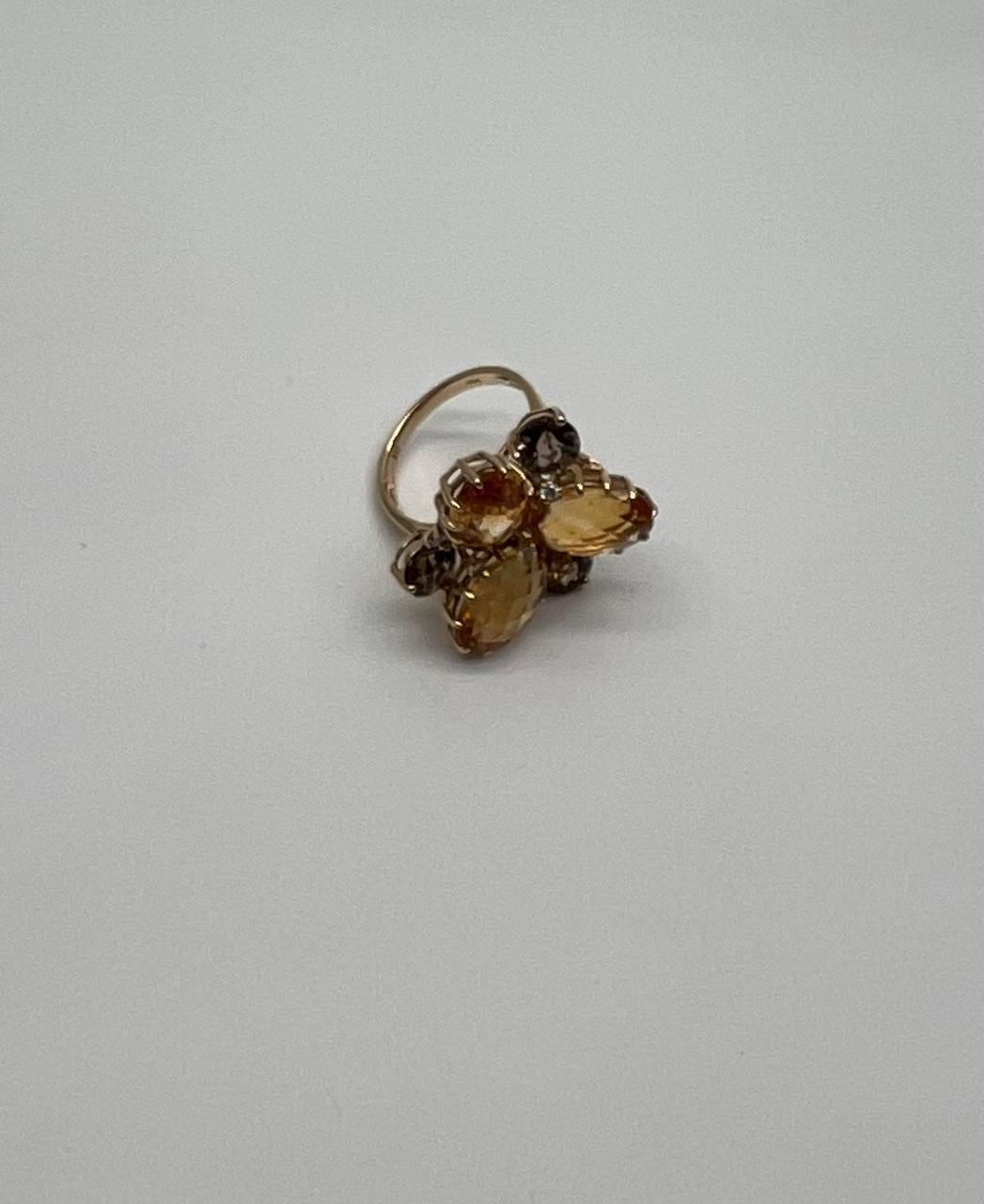 Statement Ring featuring a floral motif with faceted orange citrines and brown smoky quartz. Set in a gold setting with a cocktail setting.
14K Yellow Gold. 0.15 CTW Diamonds. Natural Smoky Quartz & Citrines.