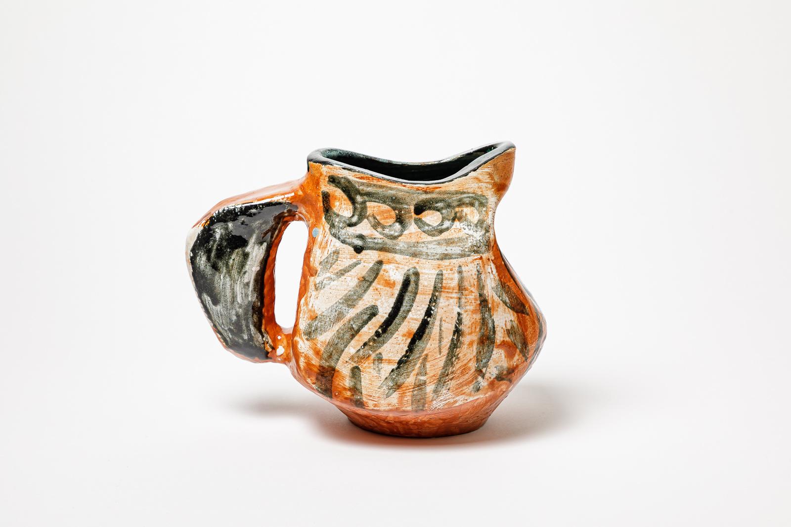 Orange and black glazed ceramic pitcher.
Artist monogram under the base. Circa 1950-1960.
H : 8.8’ x 9.8’ x 5.9’ inches.
