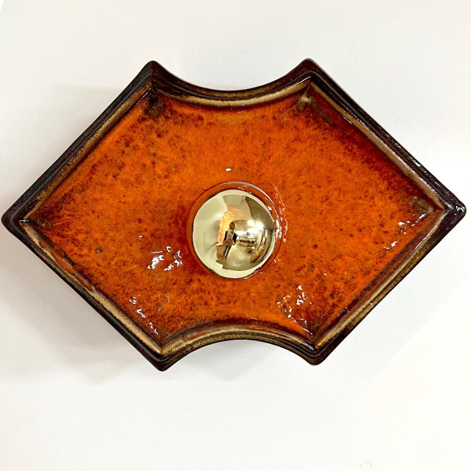 Orange and brown ceramic wall lights/flush mounts  manufactured in Germany in the 1970s.

A typical way to finish ceramic in mid-century West-Germany, Europe.
The glaze has an rich orange color which is applied on a brown base.

The lights have an