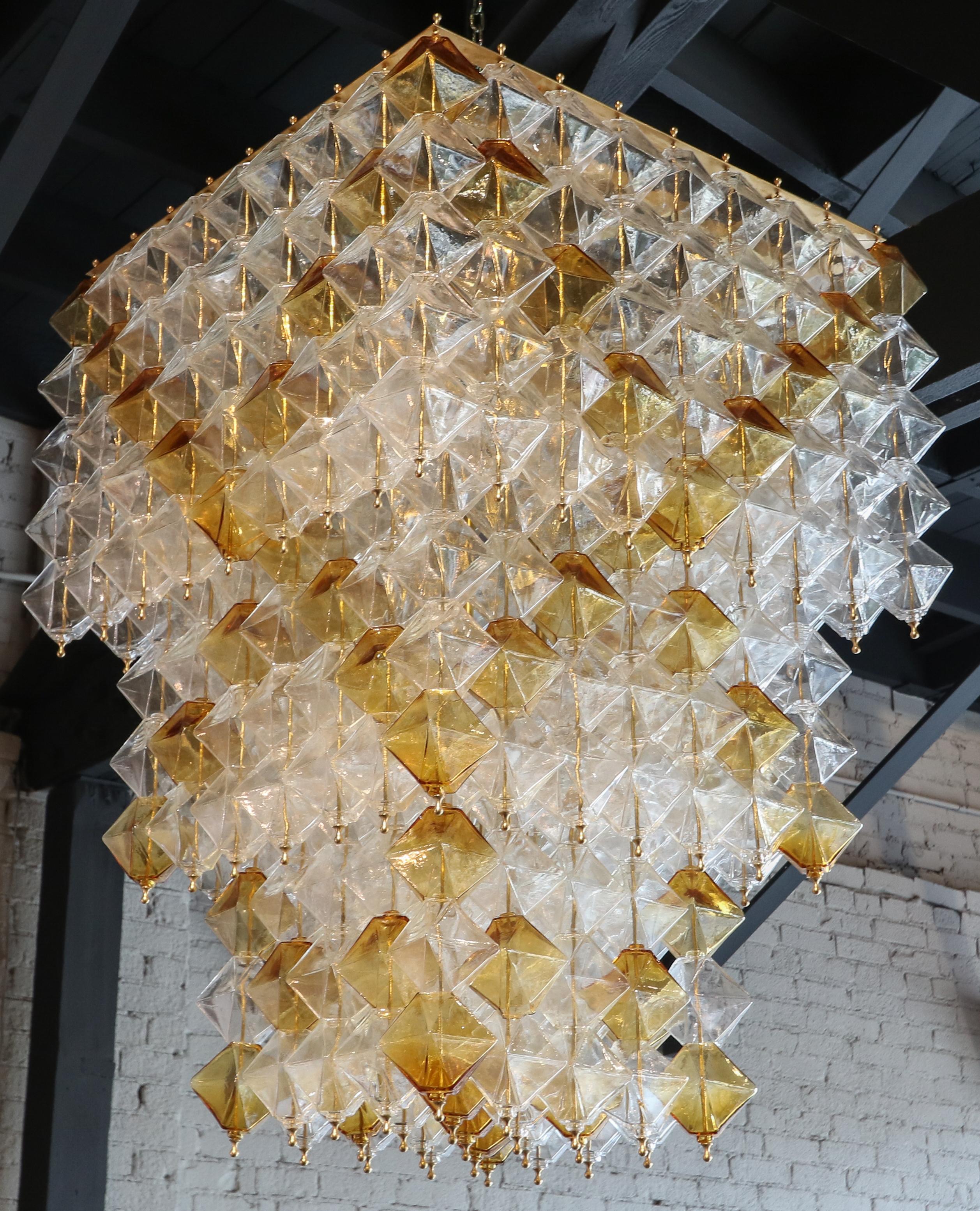 Tiered chandelier from the 1970s with clear and orange Murano glass pieces on a brass frame.