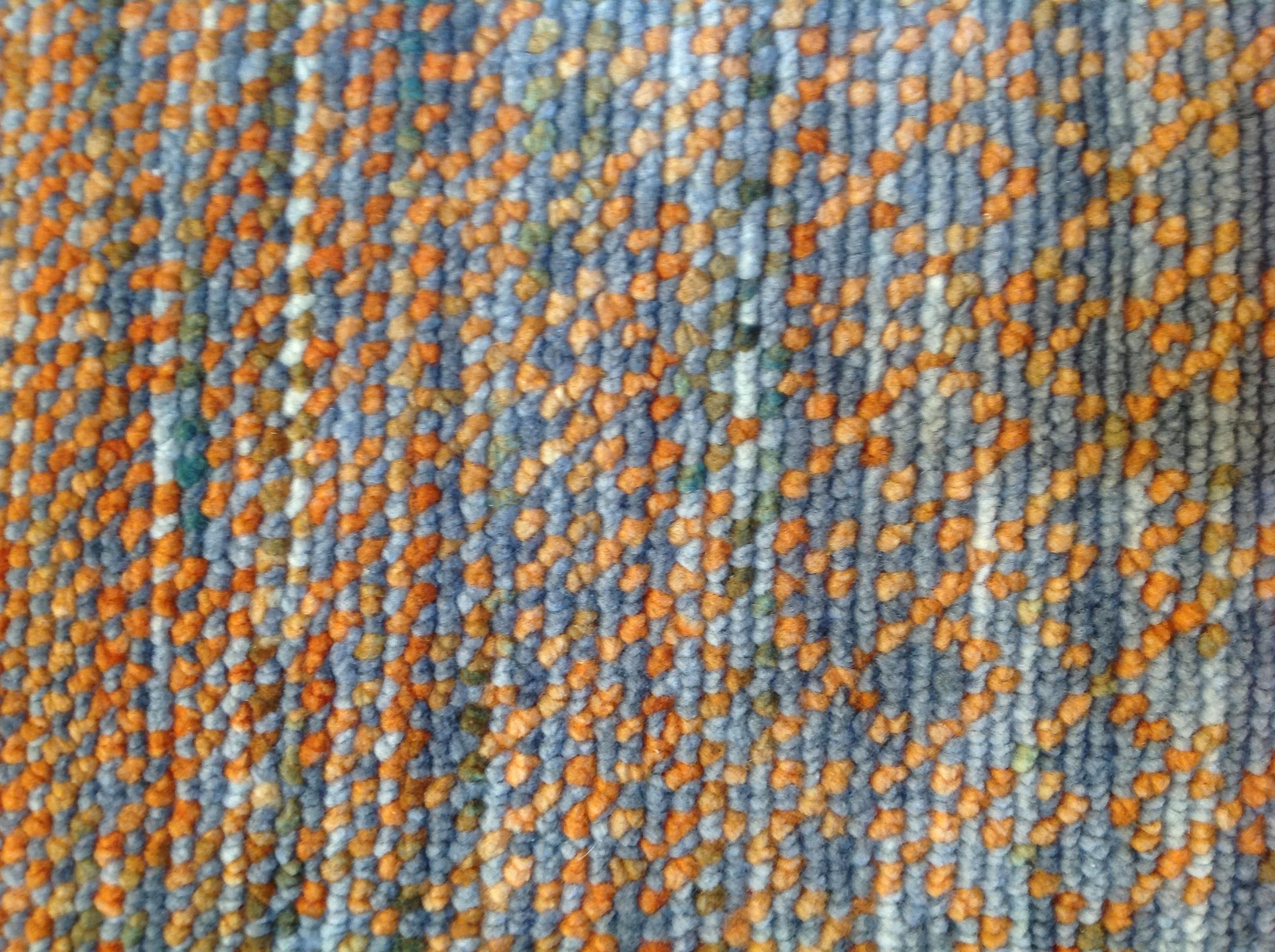 Grau- und Orangetöne verschmelzen auf subtile Weise zu einem Teppich, der Wärme ausstrahlt. Die niedrigflorige Konstruktion aus Wolle/Viskose/Baumwolle sorgt für Langlebigkeit in stark frequentierten Bereichen. Hergestellt in Indien mit pflanzlichen