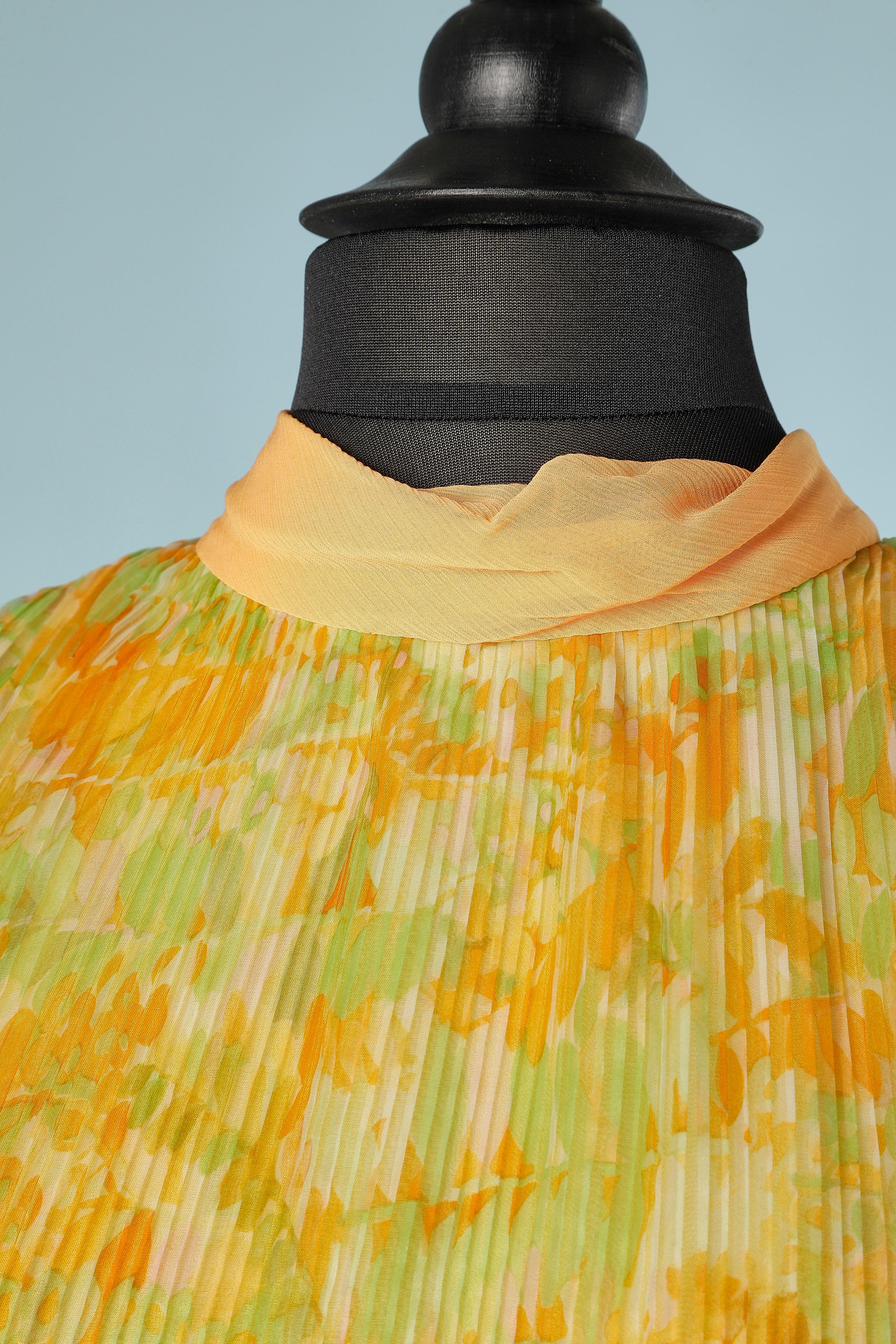 Nylon orange and green flower print with sunray pleats and chiffon neck (TIGHT BEHIND THE NECK) Acétate lining.
SIZE M
