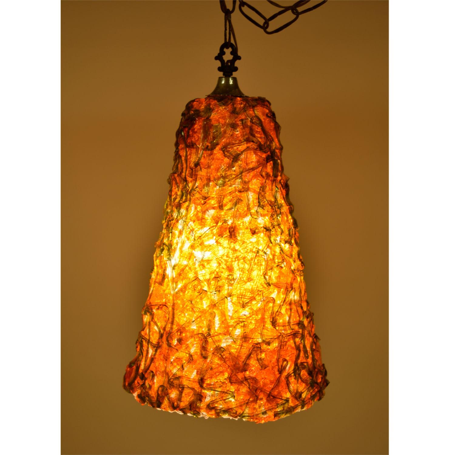 Super funky spaghetti lucite pendant lamp. Orange and green are the perfect mid-mod colors! These brilliant hues have not faded over time. The cone shaped pendant looks just as good off as it does lit up. This lamp plugs into the wall with a switch