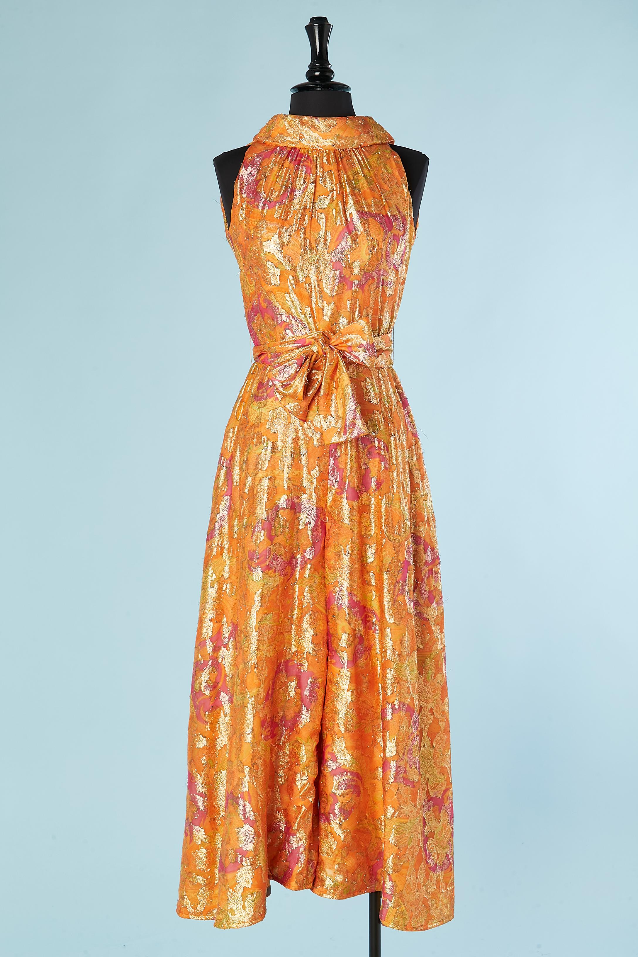 Orange and pink Paisley printed and flowers lurex patent  jumpsuit with belt. 
Zip in the middle back and hook&eye on the top. Belt and belt-loop. Lining probably acetate or rayon. 
SIZE S 