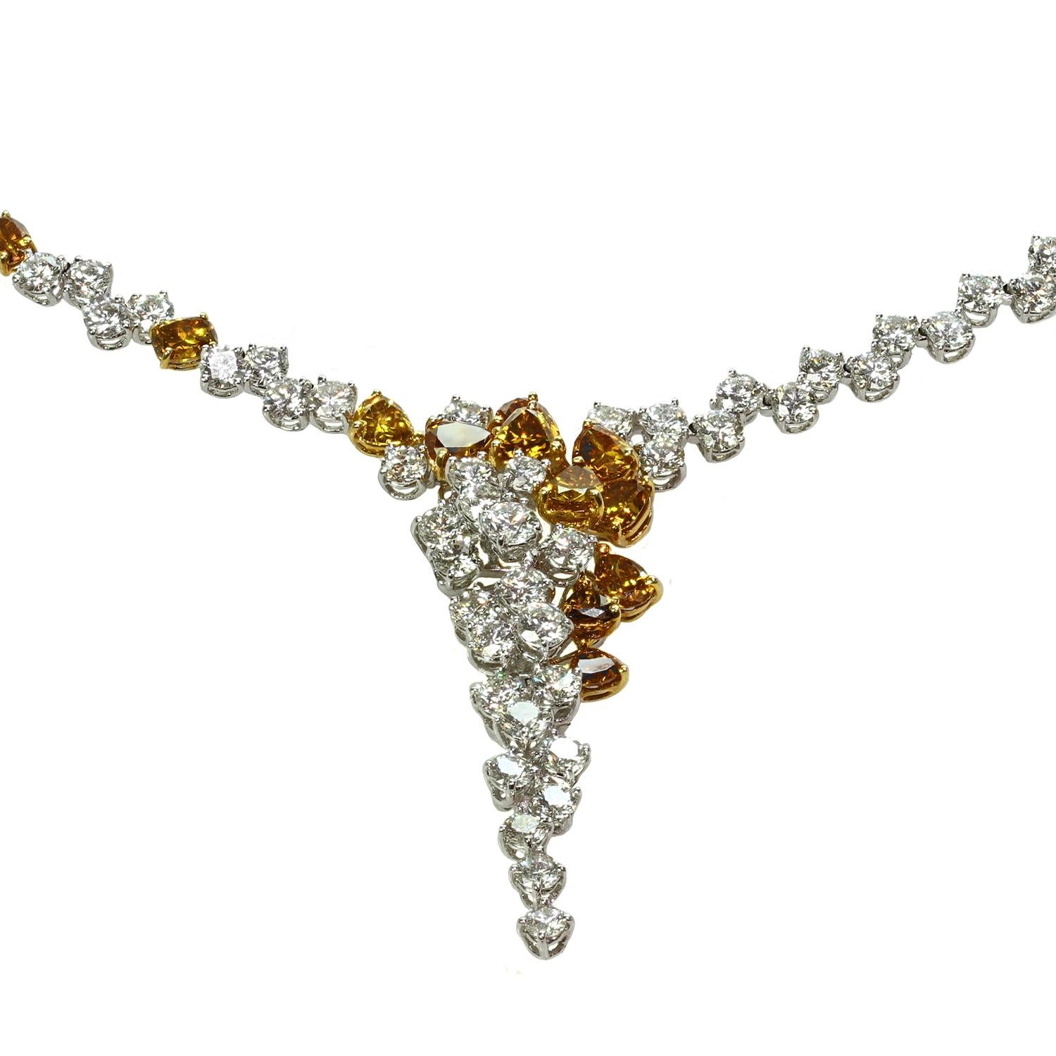 Ce somptueux collier en cascade est réalisé de manière exquise en or blanc 18 carats et comporte 22 diamants orange de fantaisie intensément vifs d'un poids total de 7,6 carats et 154 diamants blancs d'un poids total de 24,72 carats. Mesures : 43,1