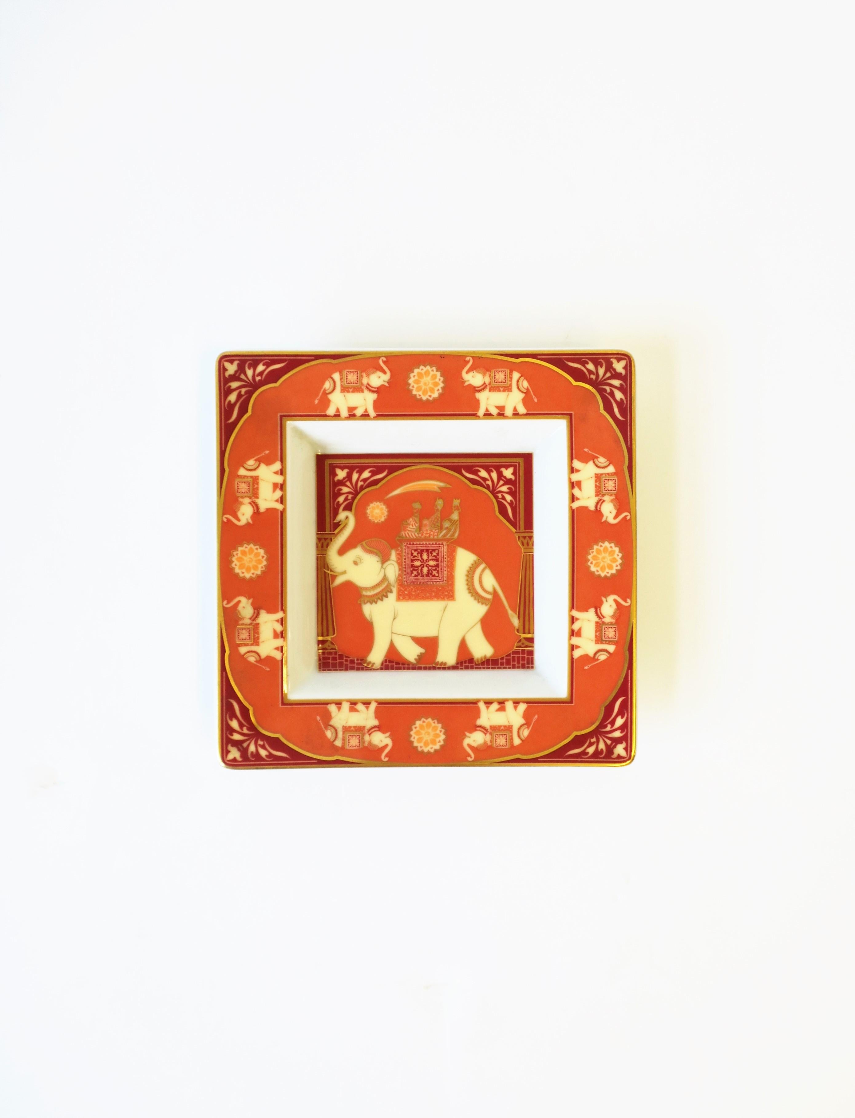 A beautiful German white porcelain jewelry dish with Elephant design by Rosenthal, circa 20th century, Germany. Dish is square with large elephant at center, smaller elephants around edge, with hues of orange, cream, red burgundy, and touches of