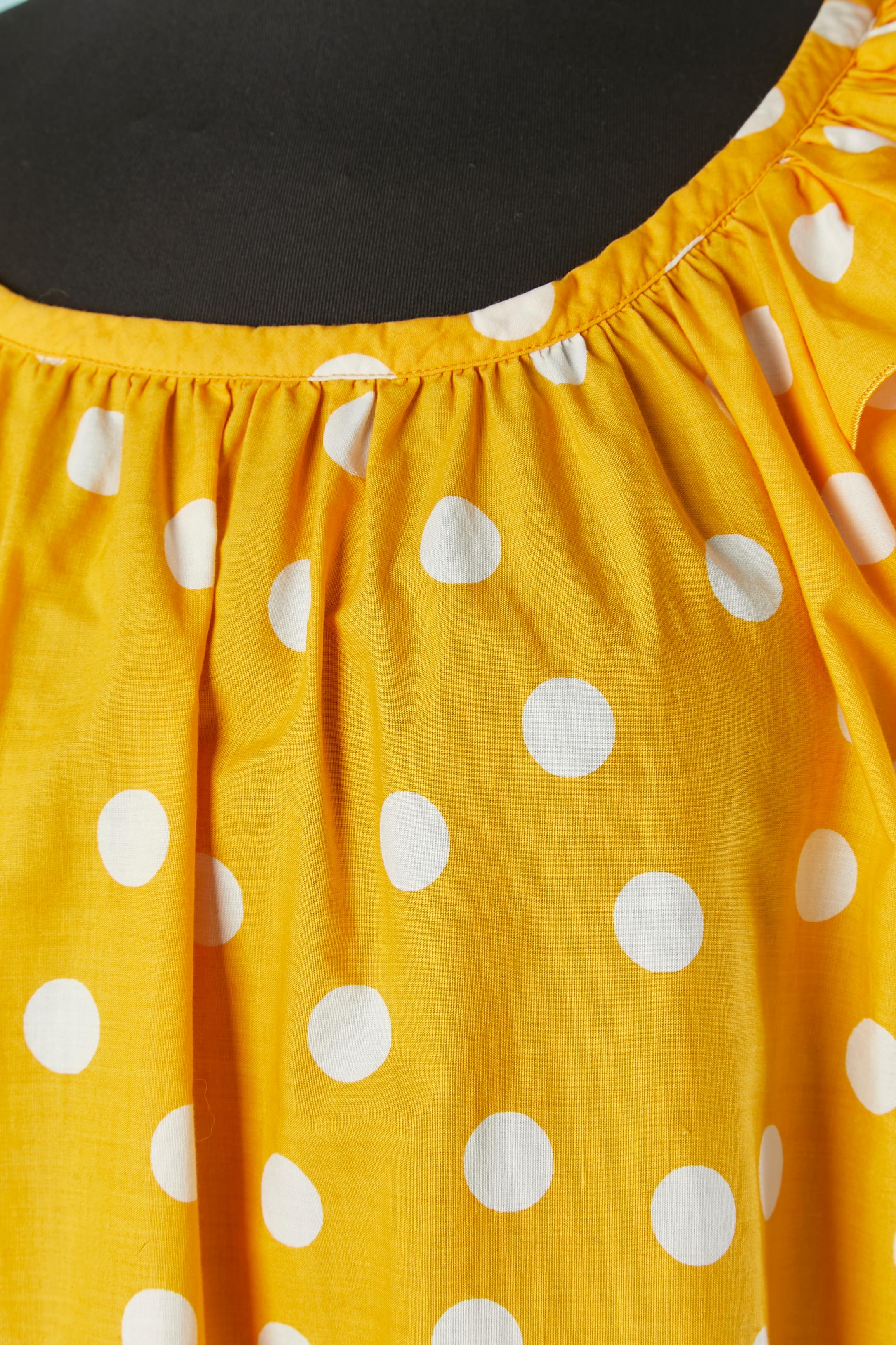 Orange and white Polka dot top with ruffles. Elastic band on the bottom edge of the sleeve.
SIZE 34 on tag but fit M 