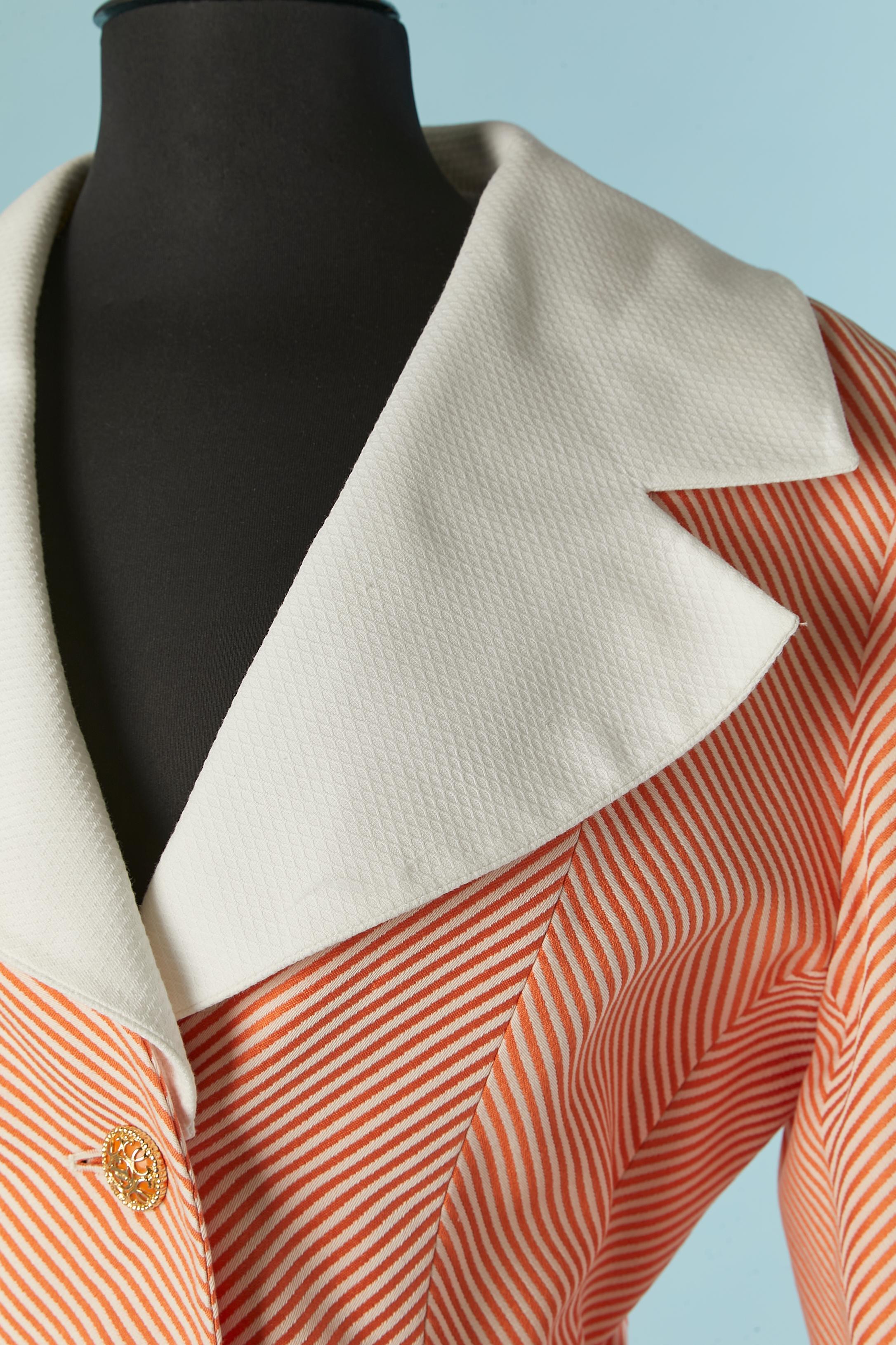 Orange and white striped skirt-suit mixed with white cotton Piqué. Impossible to read the fabric composition on the tag but the lining is probably acetate. Detachable collar and cuffs. Branded Jewellery buttons on the middle front and on the cuffs.