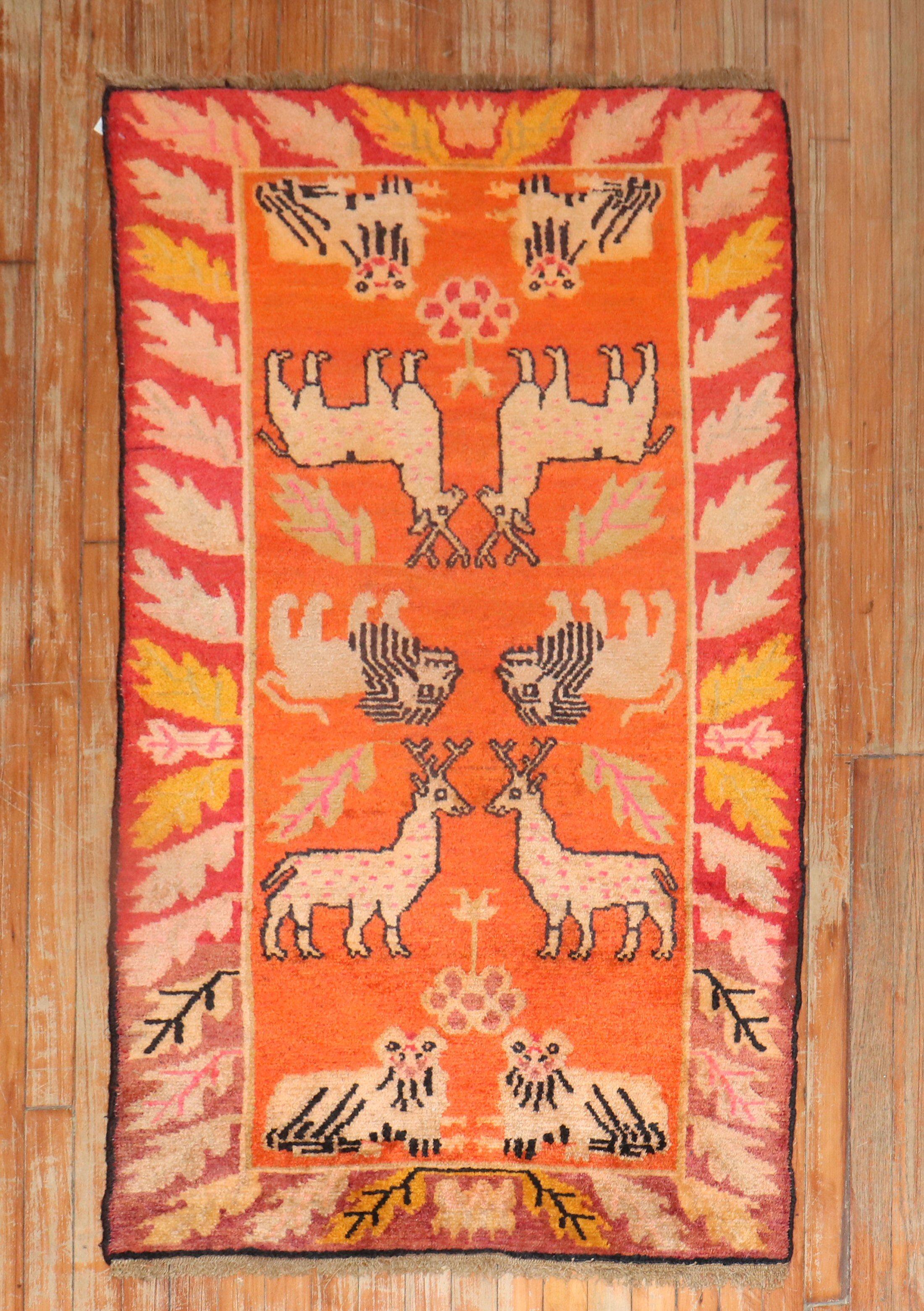 Tibetischer Teppich aus dem 2. Viertel des 20. Jahrhunderts mit einem Tierbildmotiv auf orangefarbenem Grund

Maße: 2'10