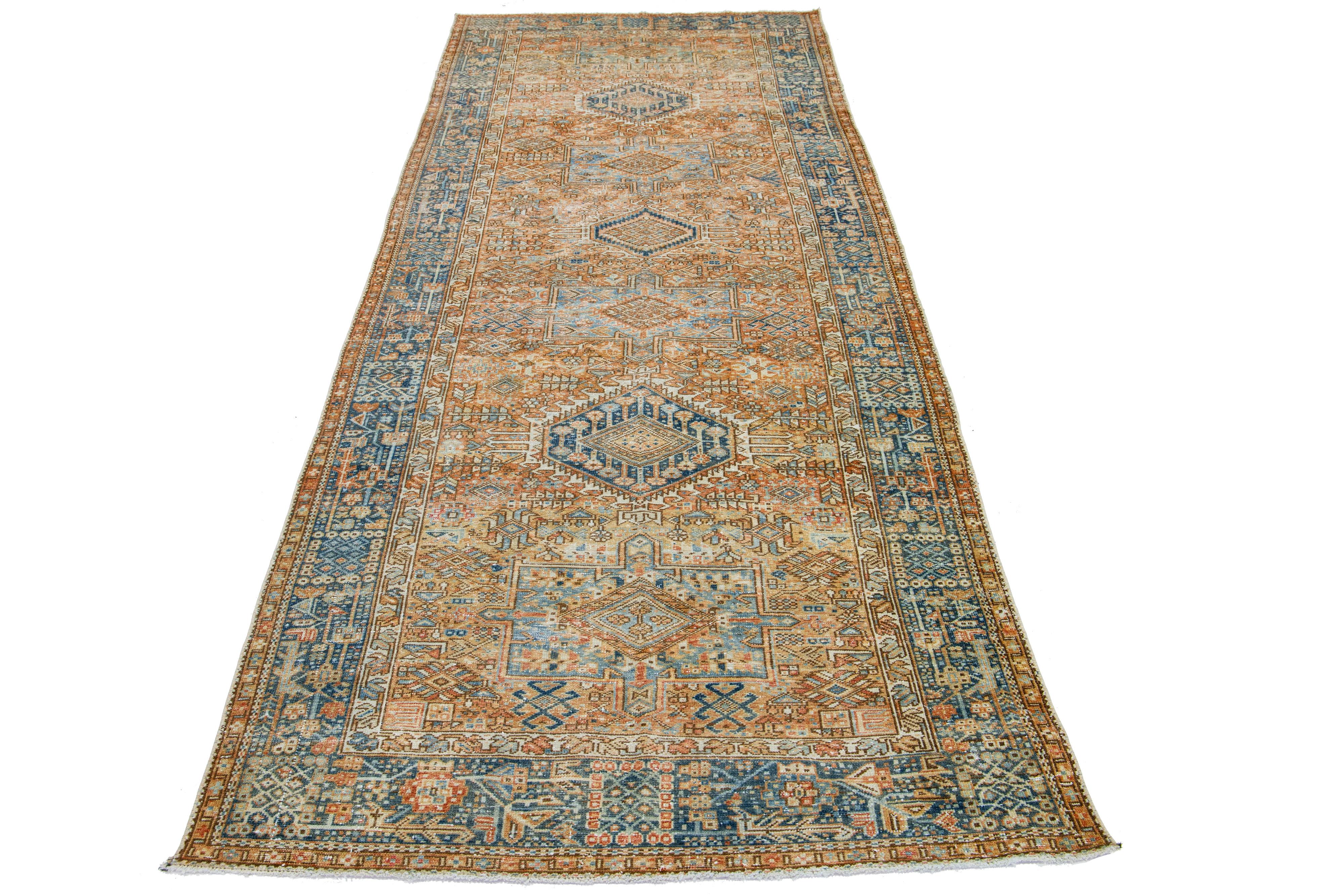 This is a beautiful 20th-century Heriz hand-knotted wool runner with an orange field. The piece boasts stunning blue and beige accents in an exquisite tribal geometric design.

This rug measures 4'7