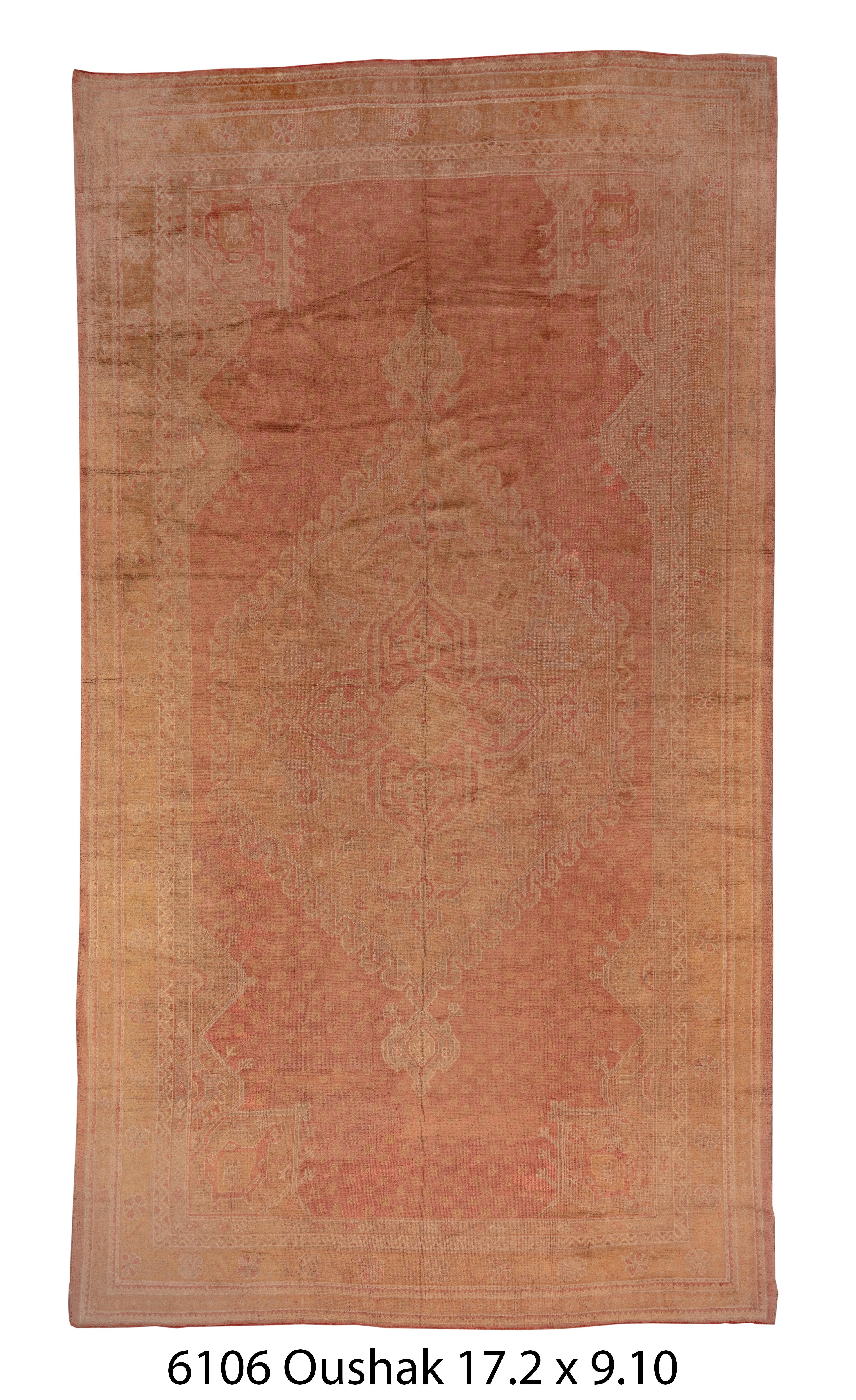 Dieser überwiegend pfirsichfarbene Teppich aus Westanatolien folgt klassischen osmanischen Archetypen mit einem flammenumrandeten Sechseckmedaillon und klobigen Arabeskenecken. Die schmale Hauptbordüre zeigt unzusammenhängende Rosetten.