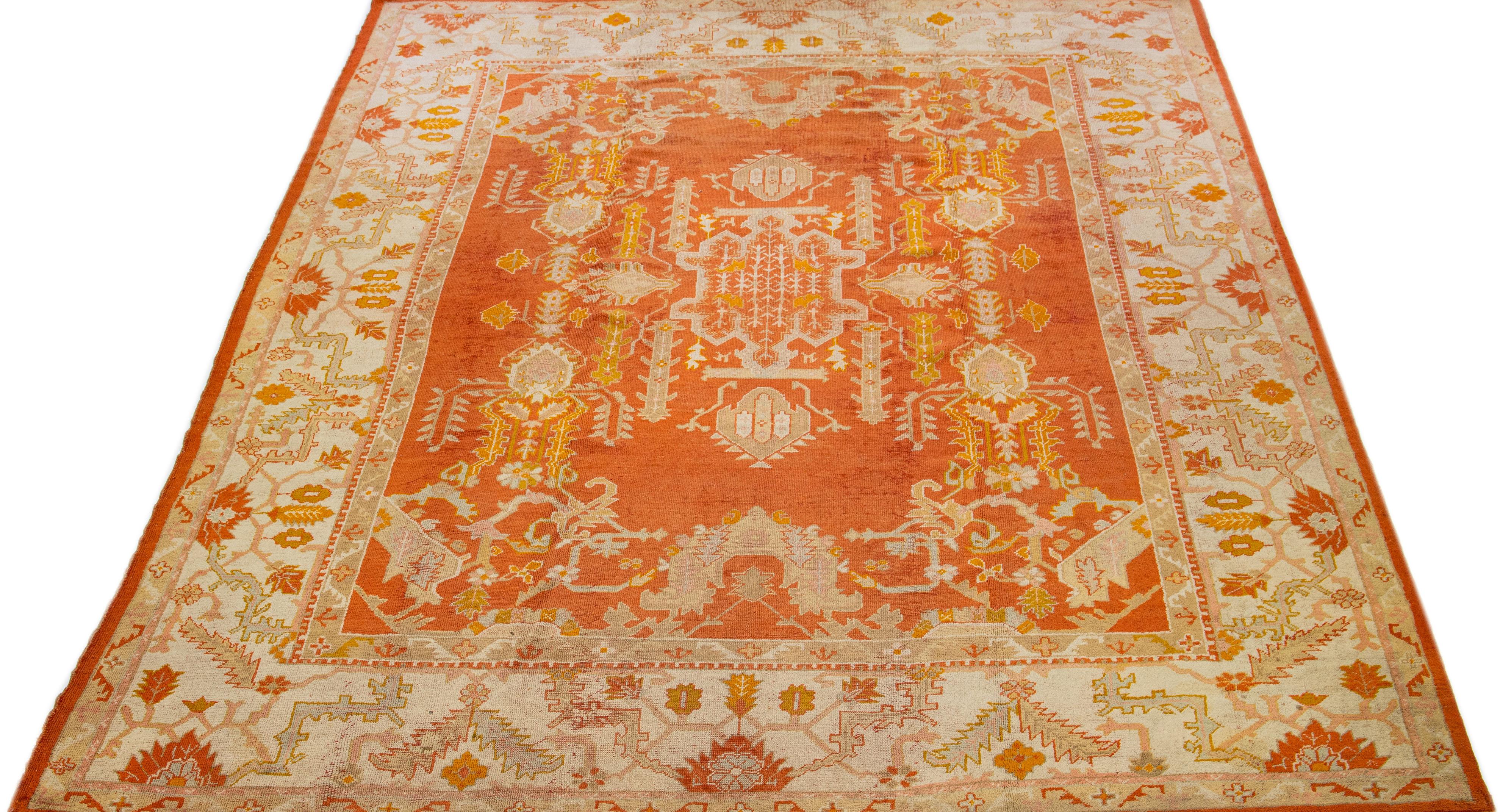 Beautiful Antique Turkish hand knotted wool rug with an orange color field. This rug has a designed frame with tan, beige, and goldenrod accent colors in a gorgeous all-over medallion floral design.

This rug measures 10'2