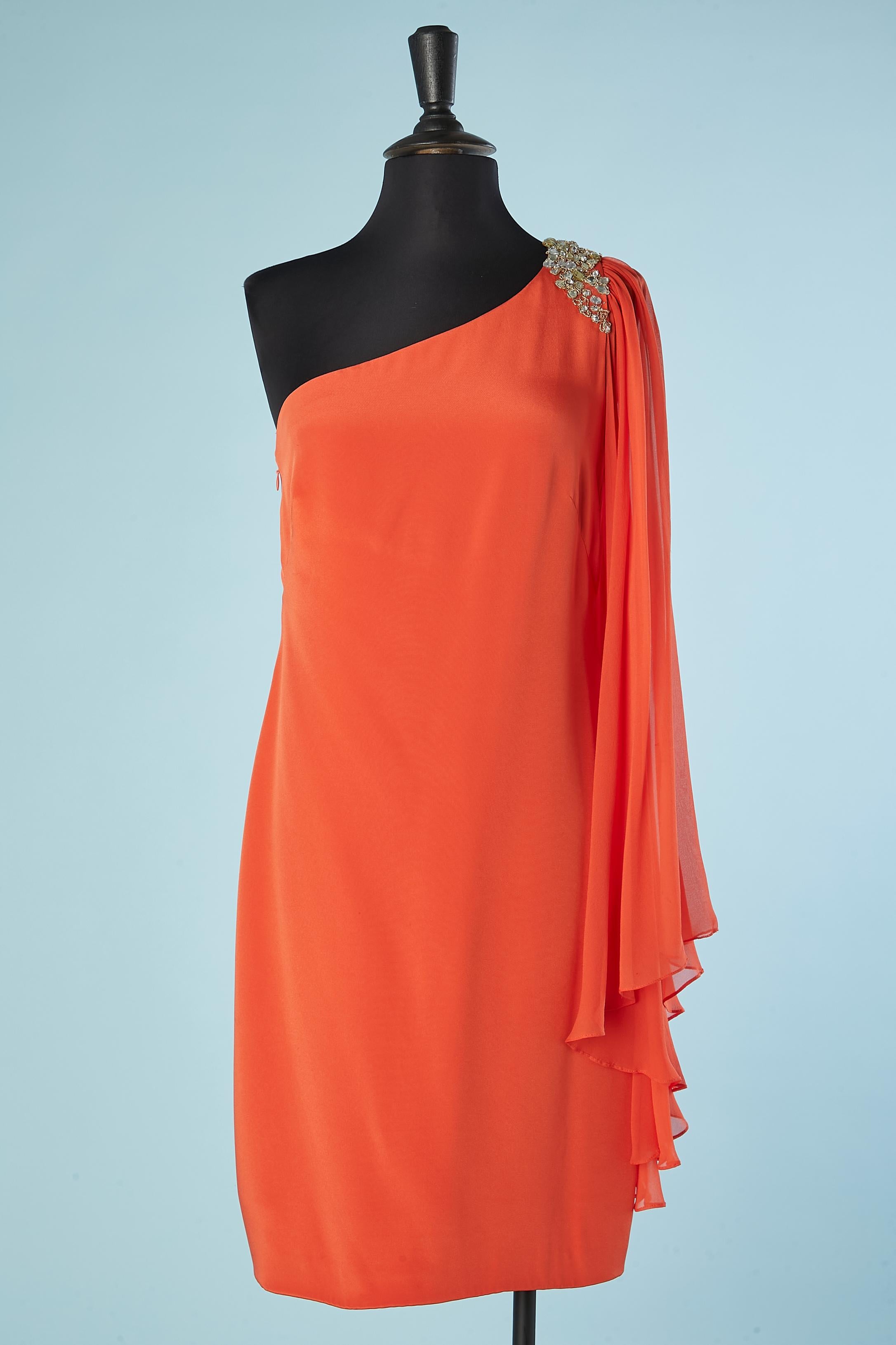 Orange asymmetrical silk dress with rhinestone and gold lurex thread embroideries on the left shoulder. Zip on the right side. The sleeve is in transparent orange silk chiffon. 
SIZE 6
