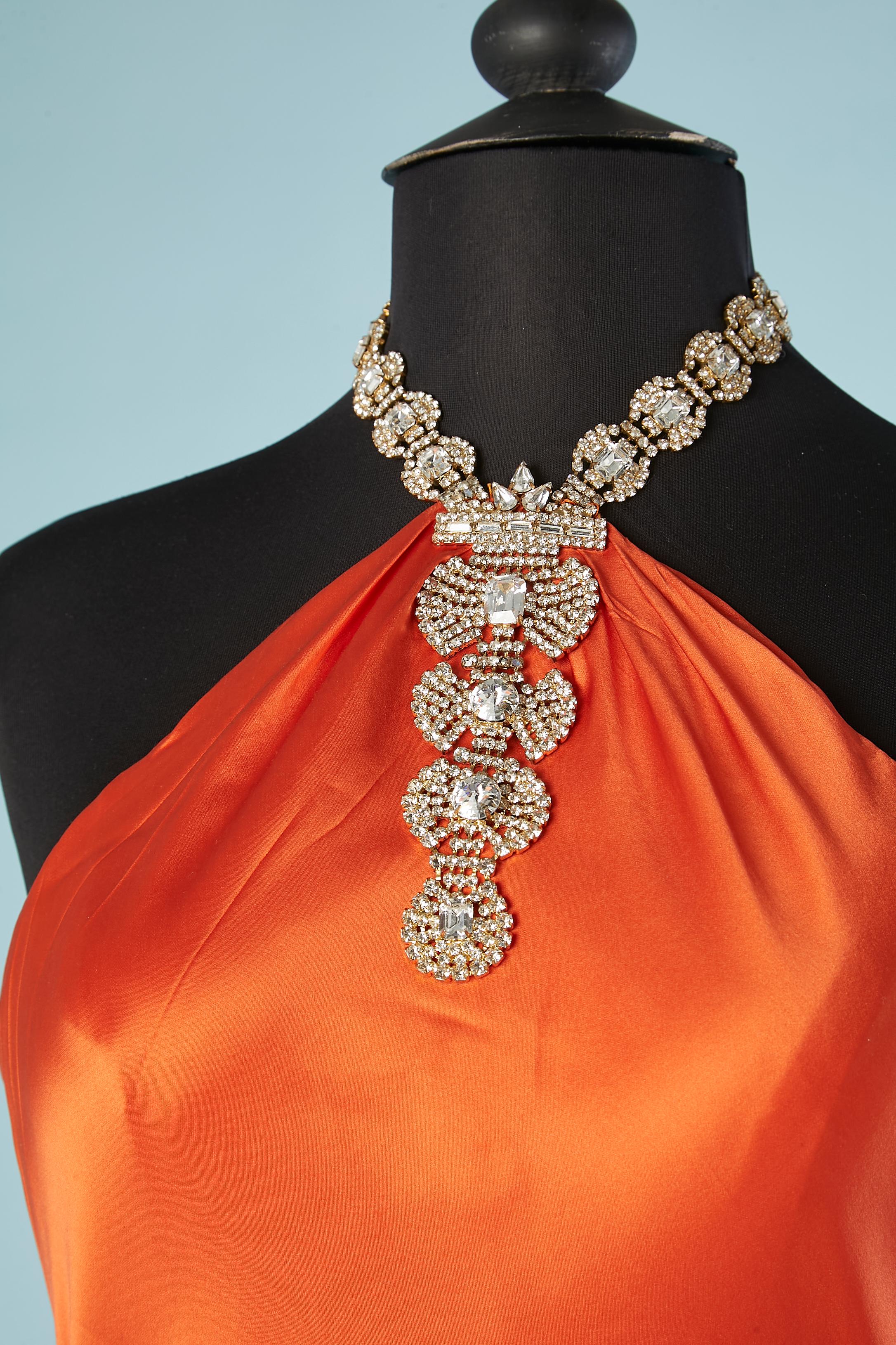 Orange backless evening dress with rhinestone neckless and draped in the middle back. No fabric composition but silk satin or polyester satin. Lining: polyester. Zip and hook& eye on the left side. Biais.
SIZE M 