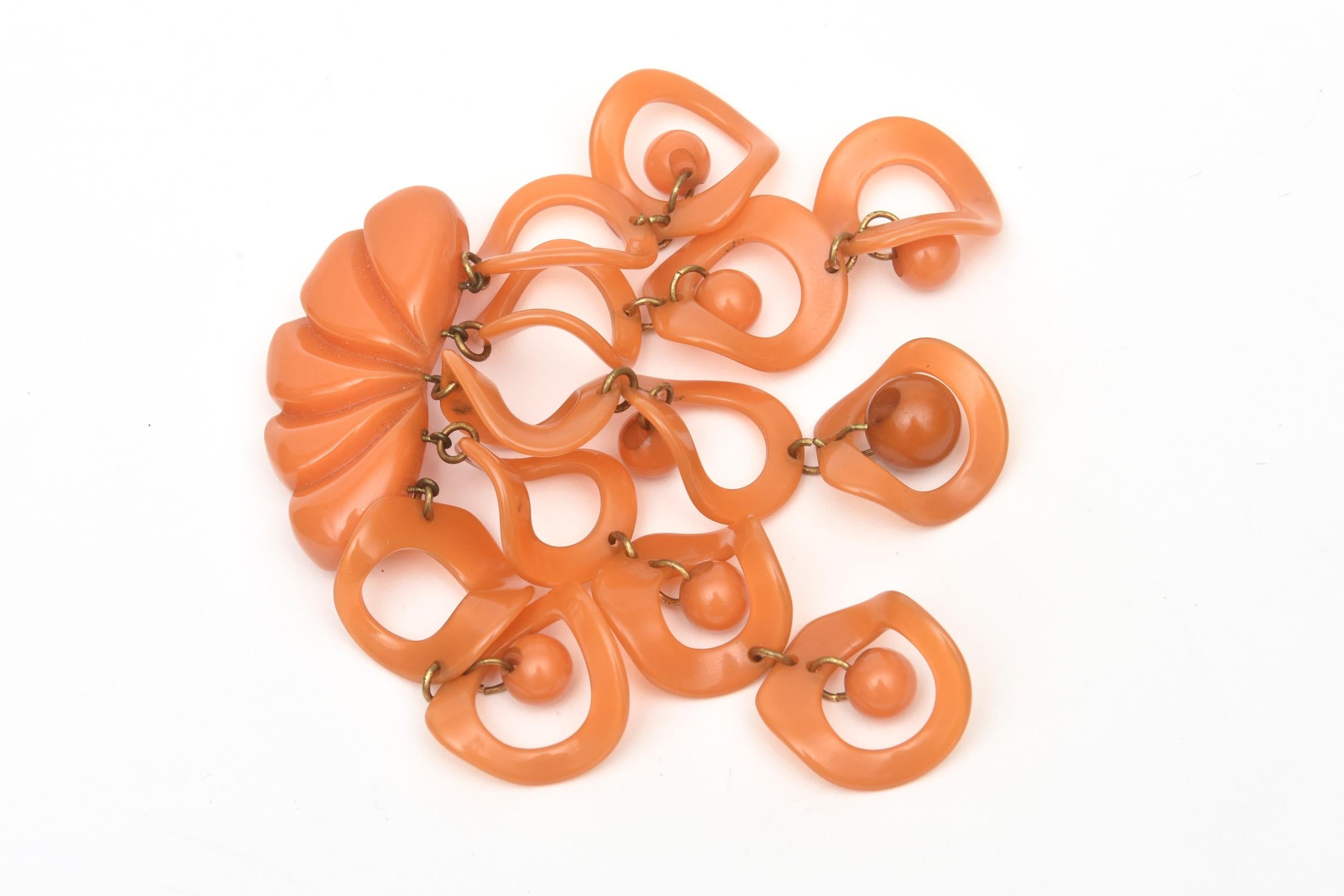 This special original vintage Art Deco orange bakelite dangler pin and or brooch is quite special and rare. It has great movement to it and the orange bakelite color is spectacular. It is from the 30's. There are 5 geometric danglers of circles and