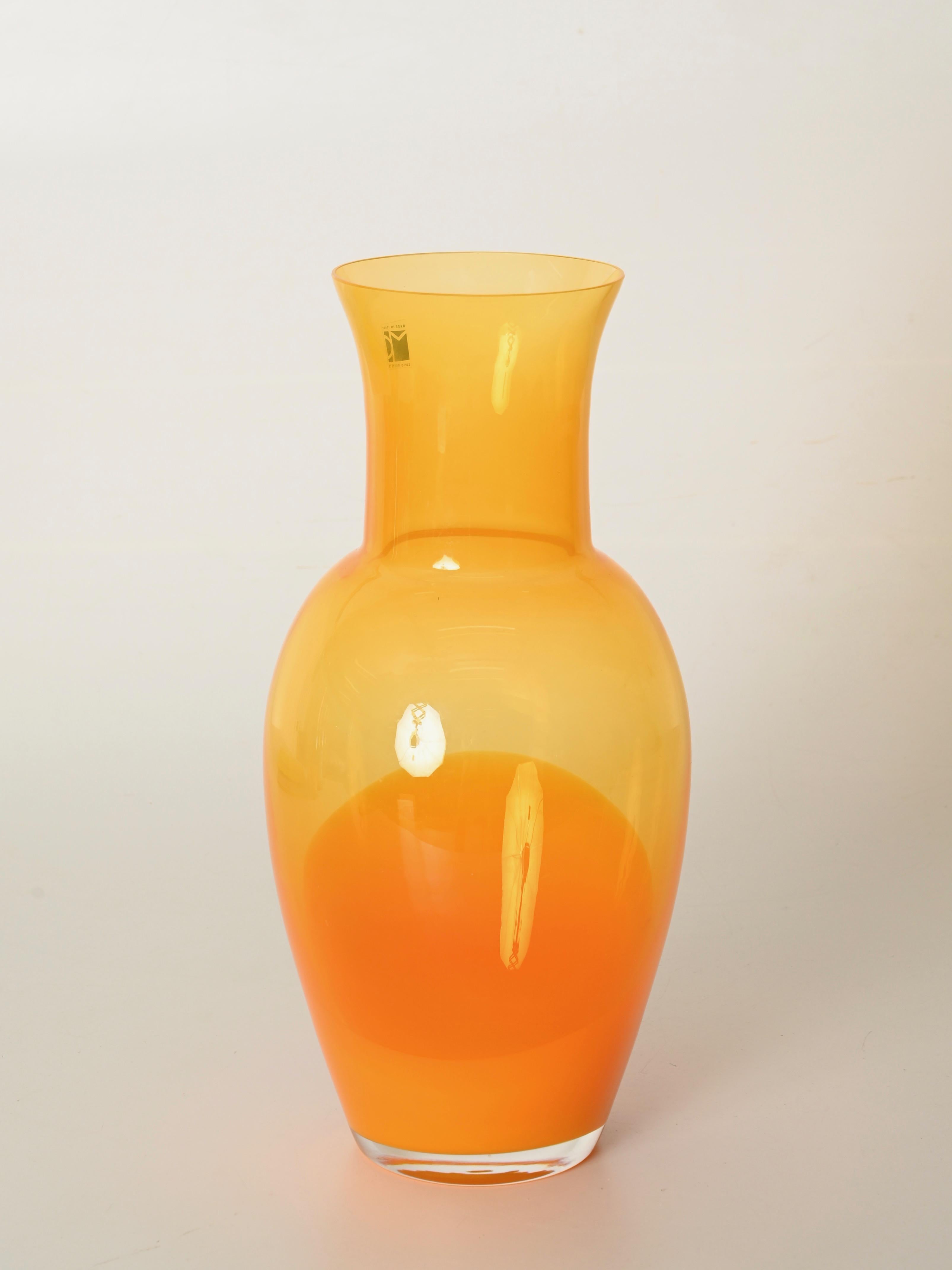 Stupendo vaso decorativo di metà secolo in vetro soffiato di Murano in uno splendido colore arancione. Questo vaso è stato disegnato da Carlo Moretti in Italia negli anni Settanta. La firma è incisa sul fondo del vaso e conserva ancora l'etichetta