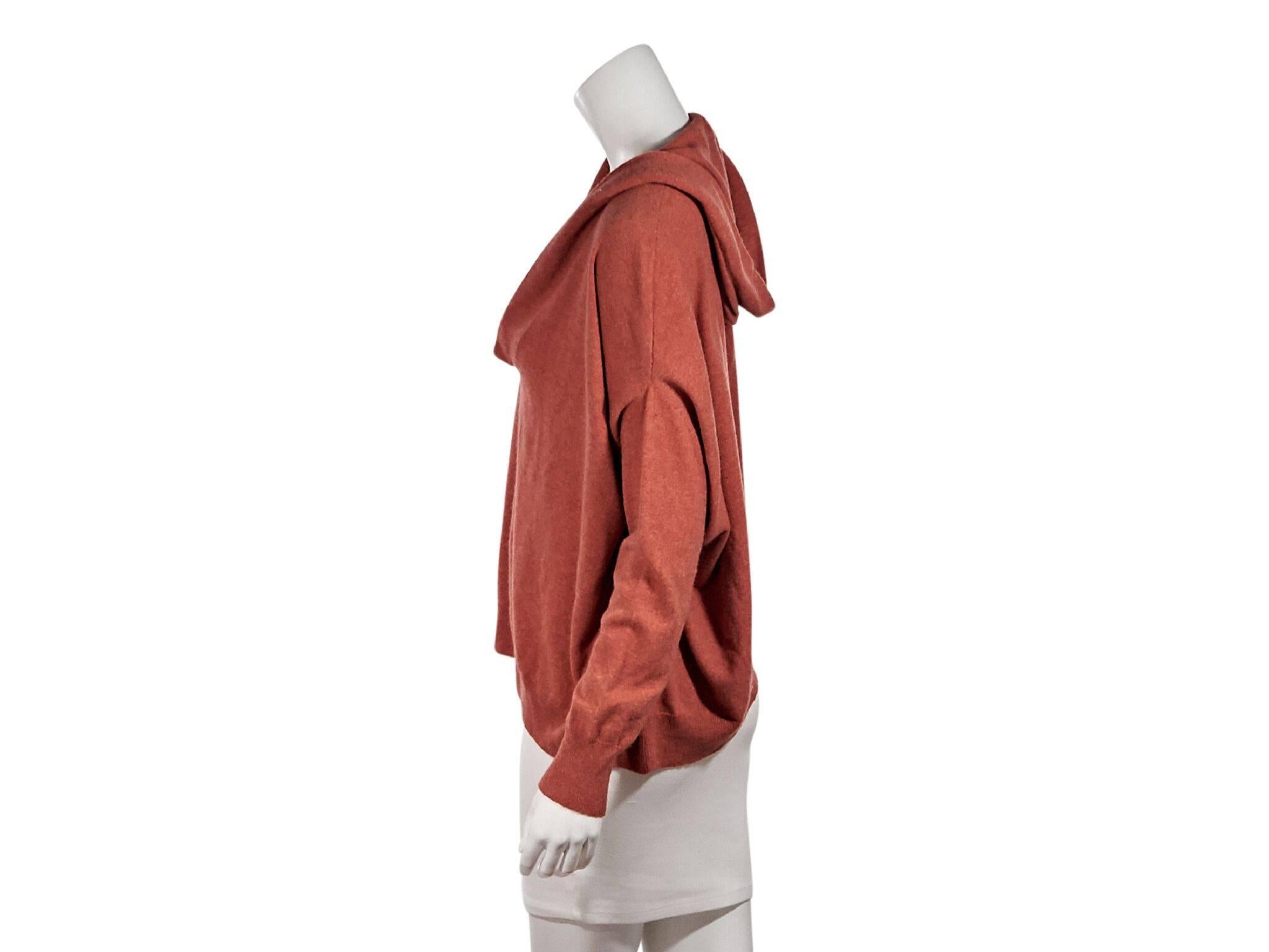 Product details:  Orange cashmere hooded sweater by Brunello Cucinelli.  Oversize fit.  V-neck.  Long dolman sleeves.  Ribbed knit cuffs and hem.  Pullover style.  72