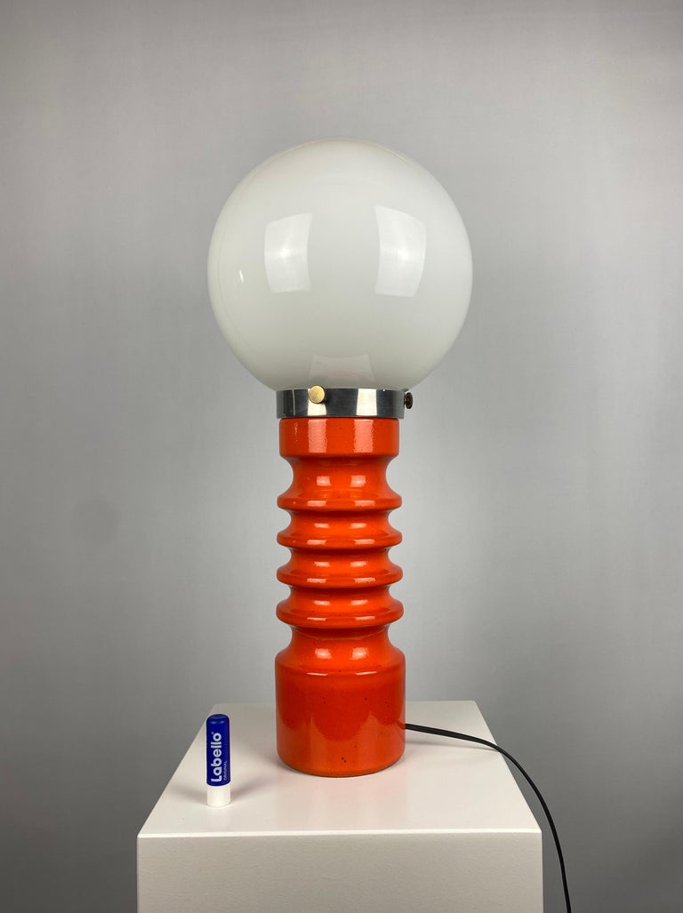 Large orange ceramic table lamp designed by Cari Zalloni for Steuler in the 1970's manufactured in West Germany. 

The glass globe is hold in place on the metal part with three screws. Has a space age feel to it. 

Marked on the bottom: W.