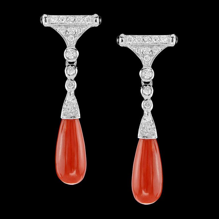 Art Deco Style Drop Earrings crafted in 9K White Gold. A pair of matched Orange Coral drops 7.65 ct. swing below a pair of sparkling diamonds set (32 pcs. 0.35 ct.) and small onyx (4 pcs. 0.24 ct.) on the side. You could wear for dinner and special