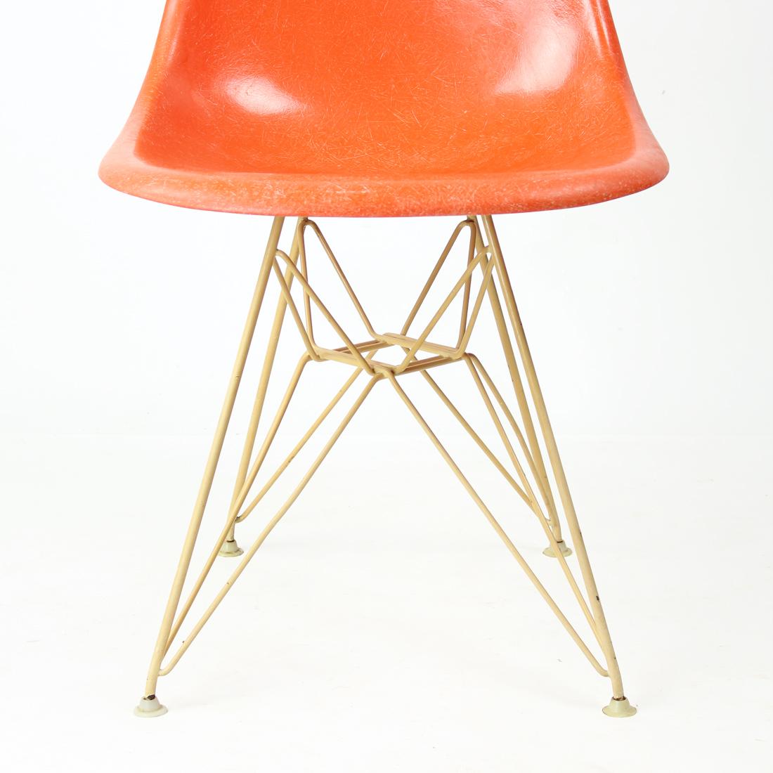 Original 1960s orange fiberglass shell chair designed by Charles and Ray Eames for Herman Miller. The scarse candy orange color has its original finish with the distinct thread texture. The shell is mounted on the original Eiffel base in light cream