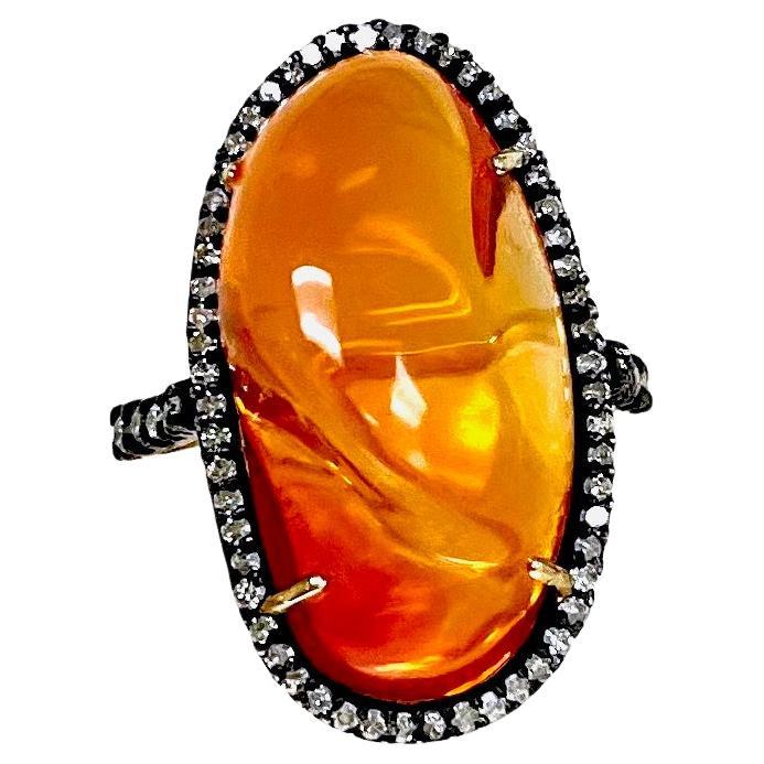 Description
Striking orange color, in a uniquely cut organically shaped Fire Opal, embellished with pave diamonds. This opal is exceptionally clear with depth of color, and is enhanced by the black rhodium pave setting. 
Item #R066

Materials and