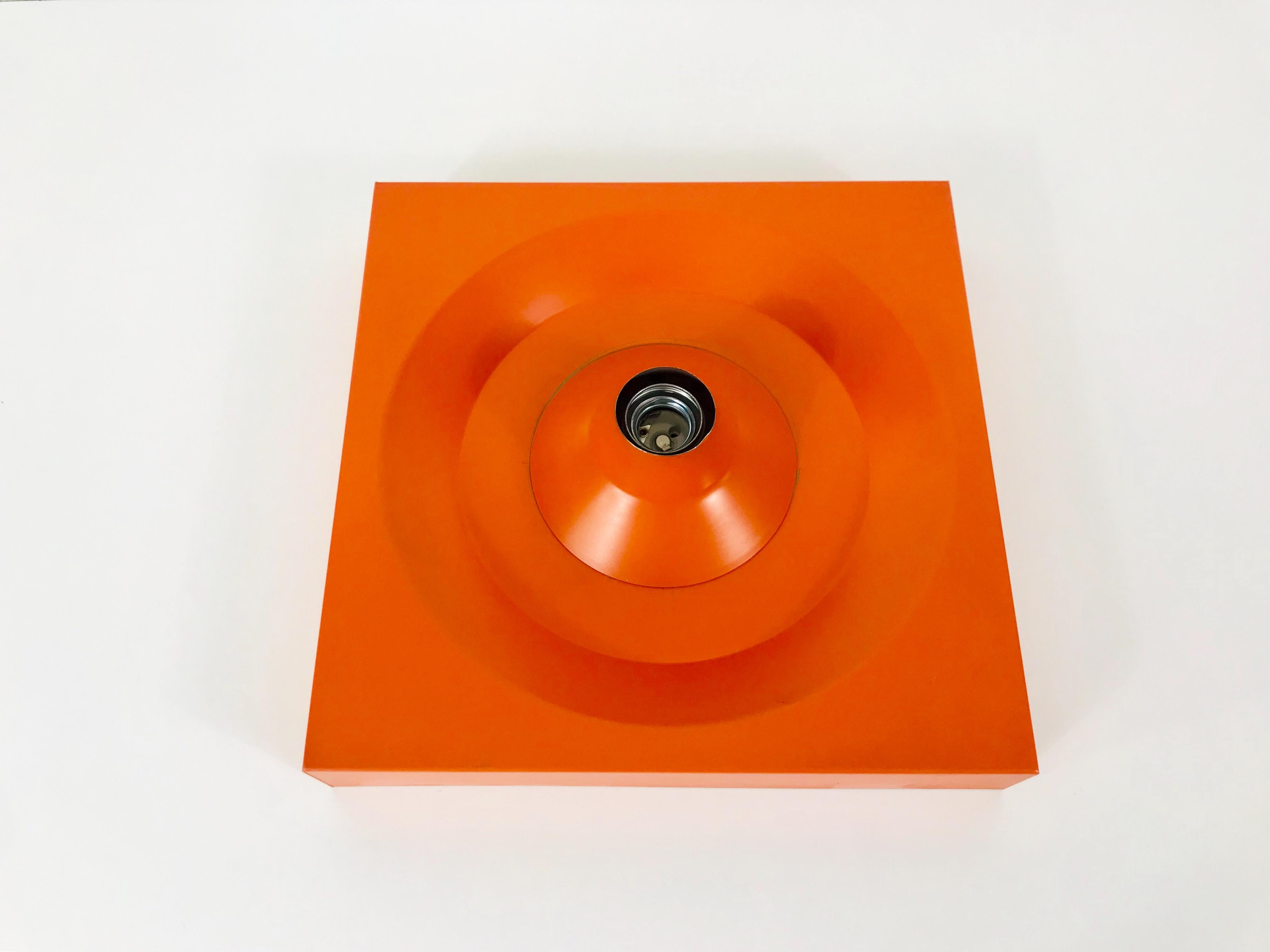 A Space Age flush mount or wall lamp by Kaiser made in Germany in the 1970s. It was designed by Klaus Hempel. The body of the lamp is made of full metal and has a beautiful orange color. 

Measurements:

Height 5 cm

Diameter 31 cm

The