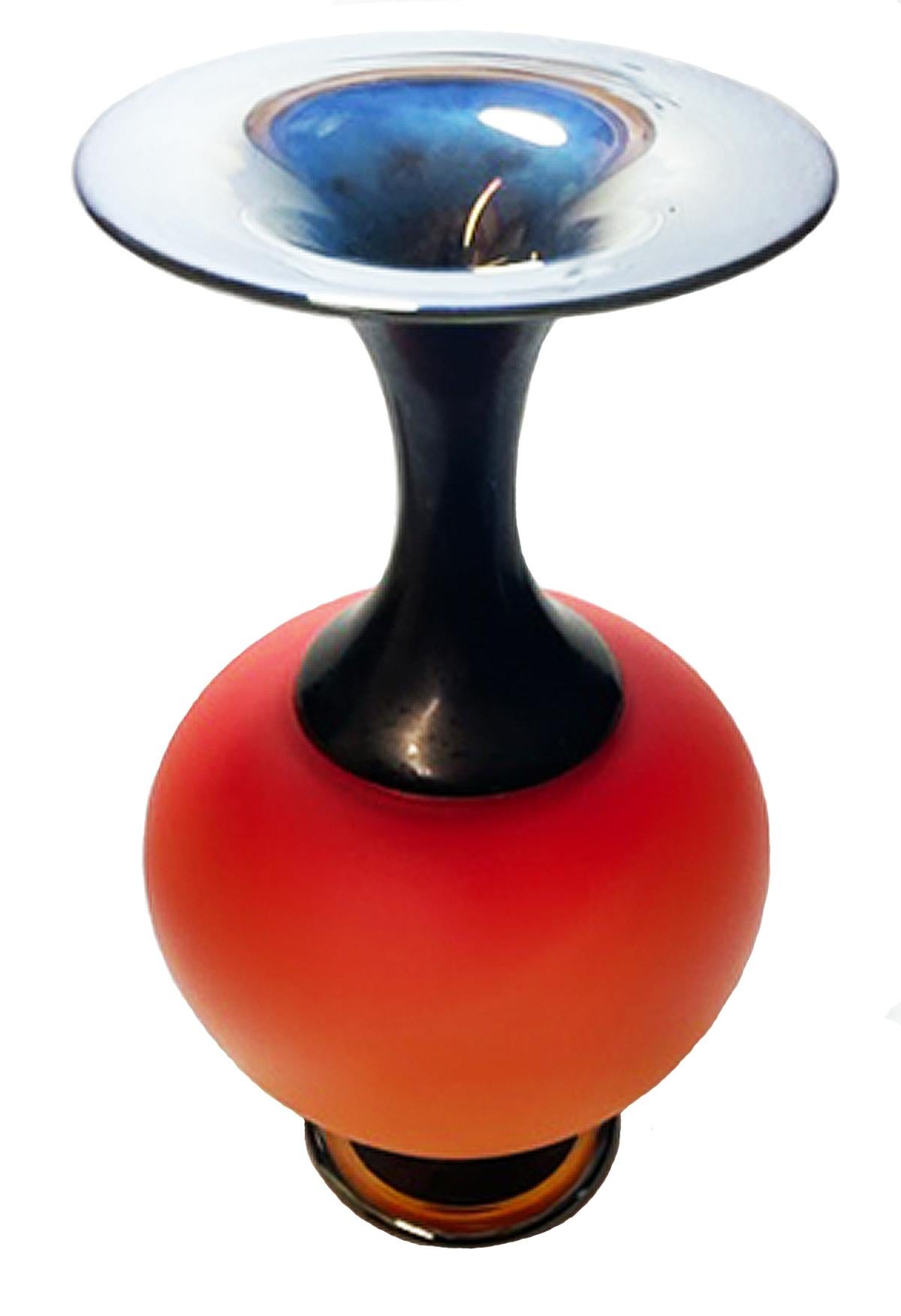 This piece is overlay blown and sandblast etched glass. It is part of a series of pieces sold in the artfair market. The blank vessel is blown with color layers and a lustered, folded rim glass foot. The last exterior layer is black which in this