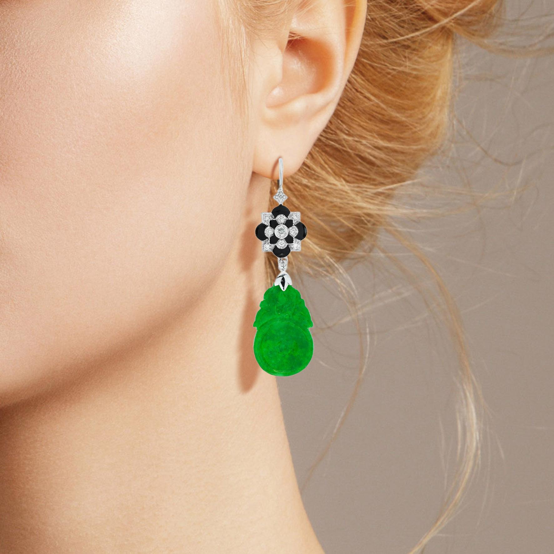 The natural jade in these lovely earrings has some very special shape. Both pieces have a strong green color and well orange fruit carvings. The jade is suspended in a 9k white gold setting with diamond floral on the top. The earrings transfer their