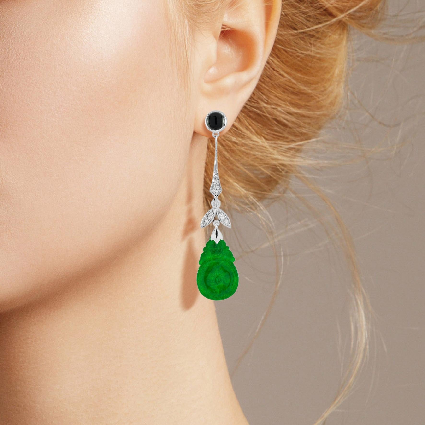 The natural jade in these lovely earrings has some very special shape. Both pieces have a strong green color and well orange fruit carvings. The jade is suspended in a 9k white gold setting with diamond leaf and round onyx on the top. The earrings