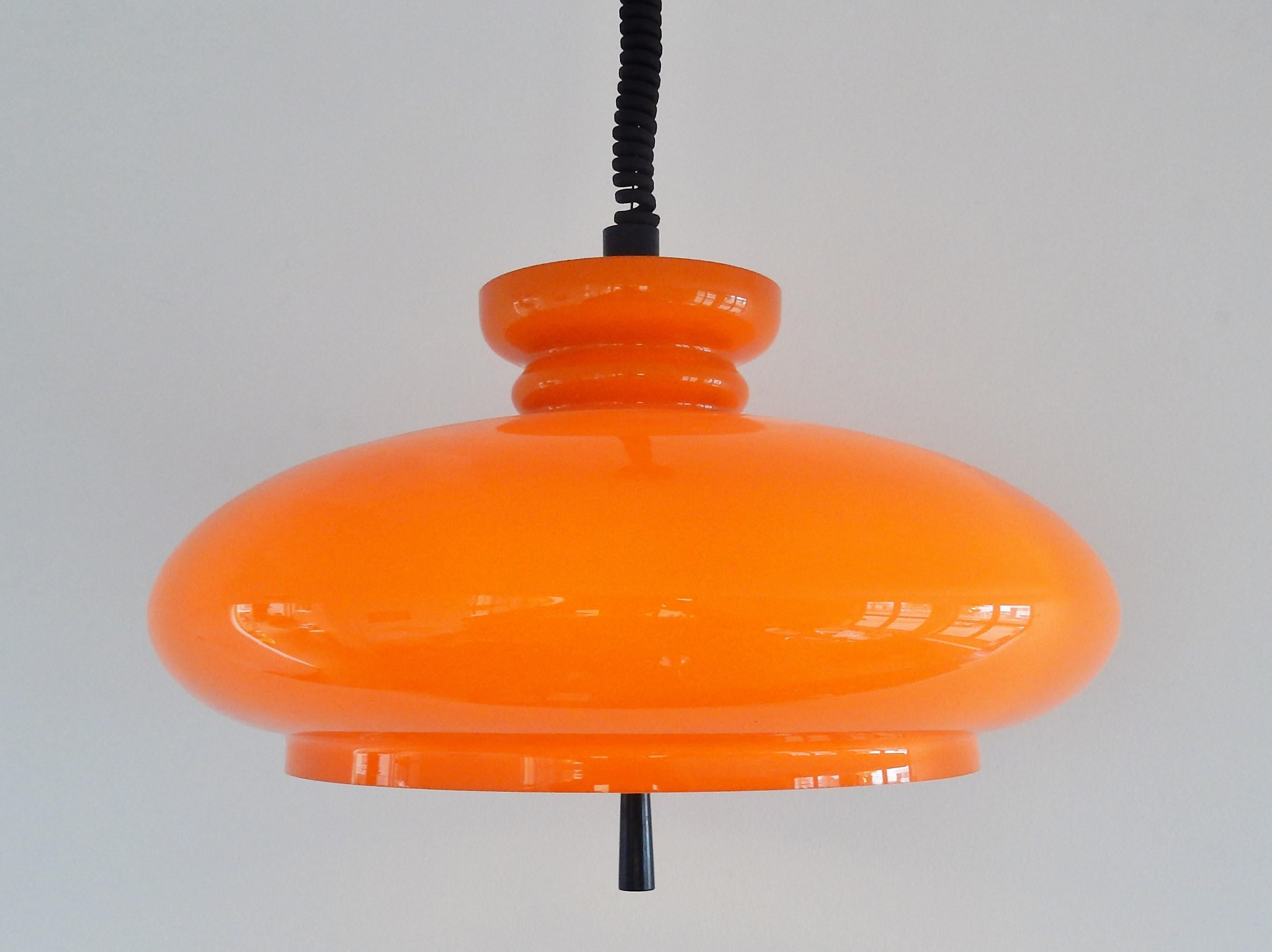 This beautiful orange glass pendant model 'Bowl' was made by RAAK in the 1970s. It is mouth blown and handcut by a master glassblower, that marks the individuality of each lamp. The orange glass, white opaline glass and plastic diffusor inside gives