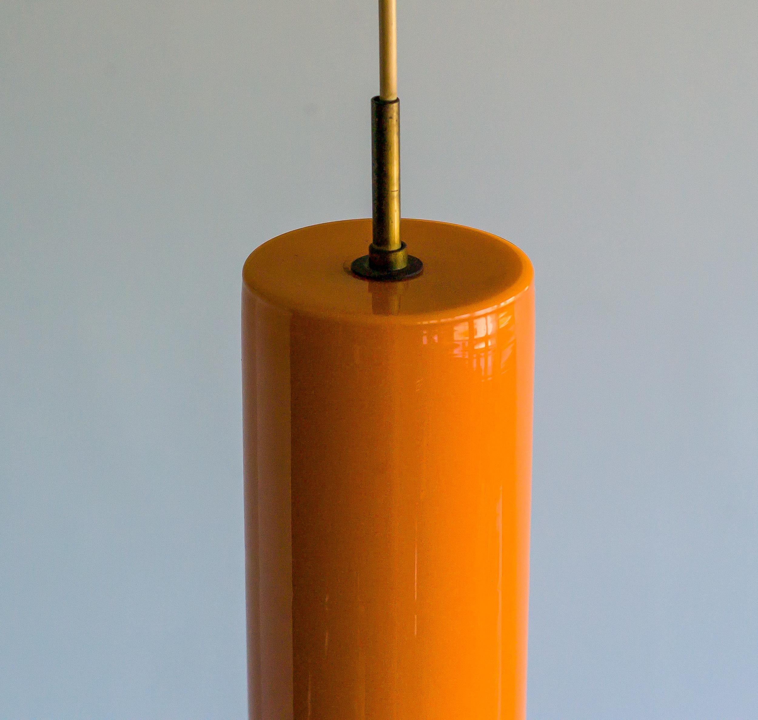Pendentif en verre de Murano italien soufflé à la main n° 011.11, conçu par Massimo Vignelli et exécuté par le spécialiste du verre de Murano Venini. Exemplaire original avec quincaillerie en laiton, vers 1955.
Superbe couleur orange typique des