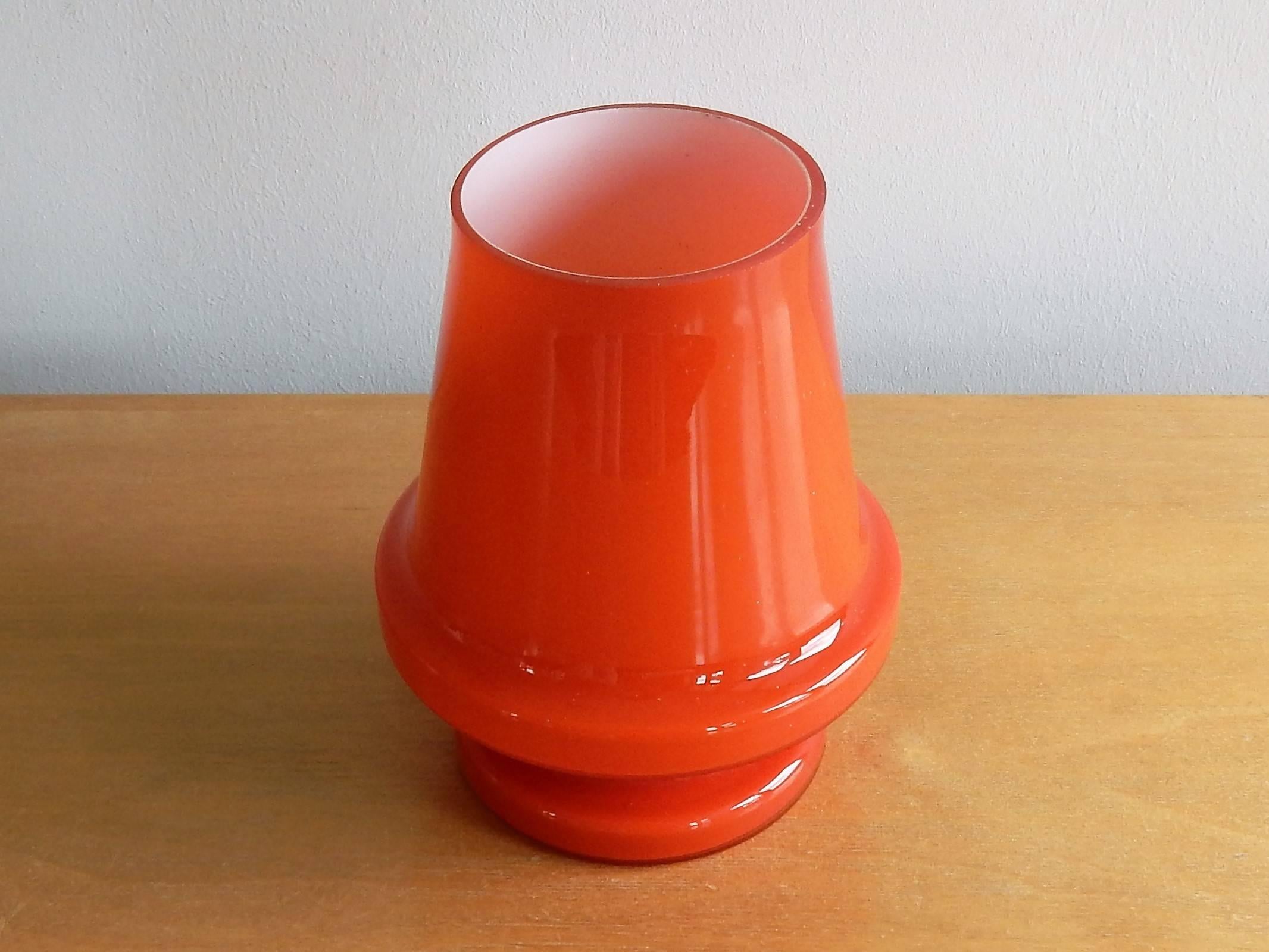 This orange colored glass table lamp with a white inside is made by Flygsfors in Sweden in the 1970s. It gives a beautiful warm light. This lamp is in a very good condition.