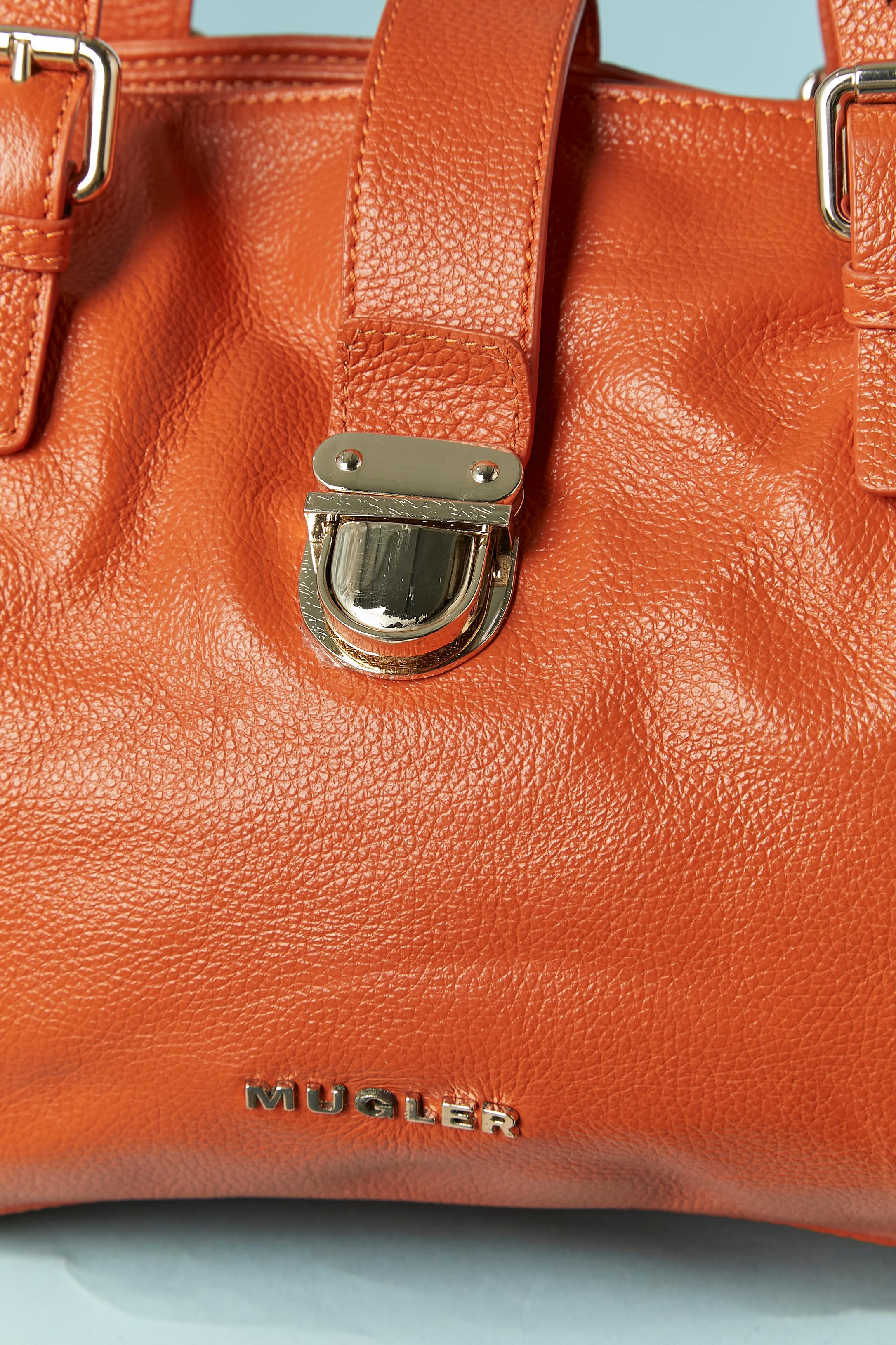 Orange grained leather hand bag. The bag is made of 3 compartments ( 2 with snap closure and one with zip closure) 
Leather strap on the middle top with clasp closure on the front. Back pocket with zip closure. Inside the compartment with zip