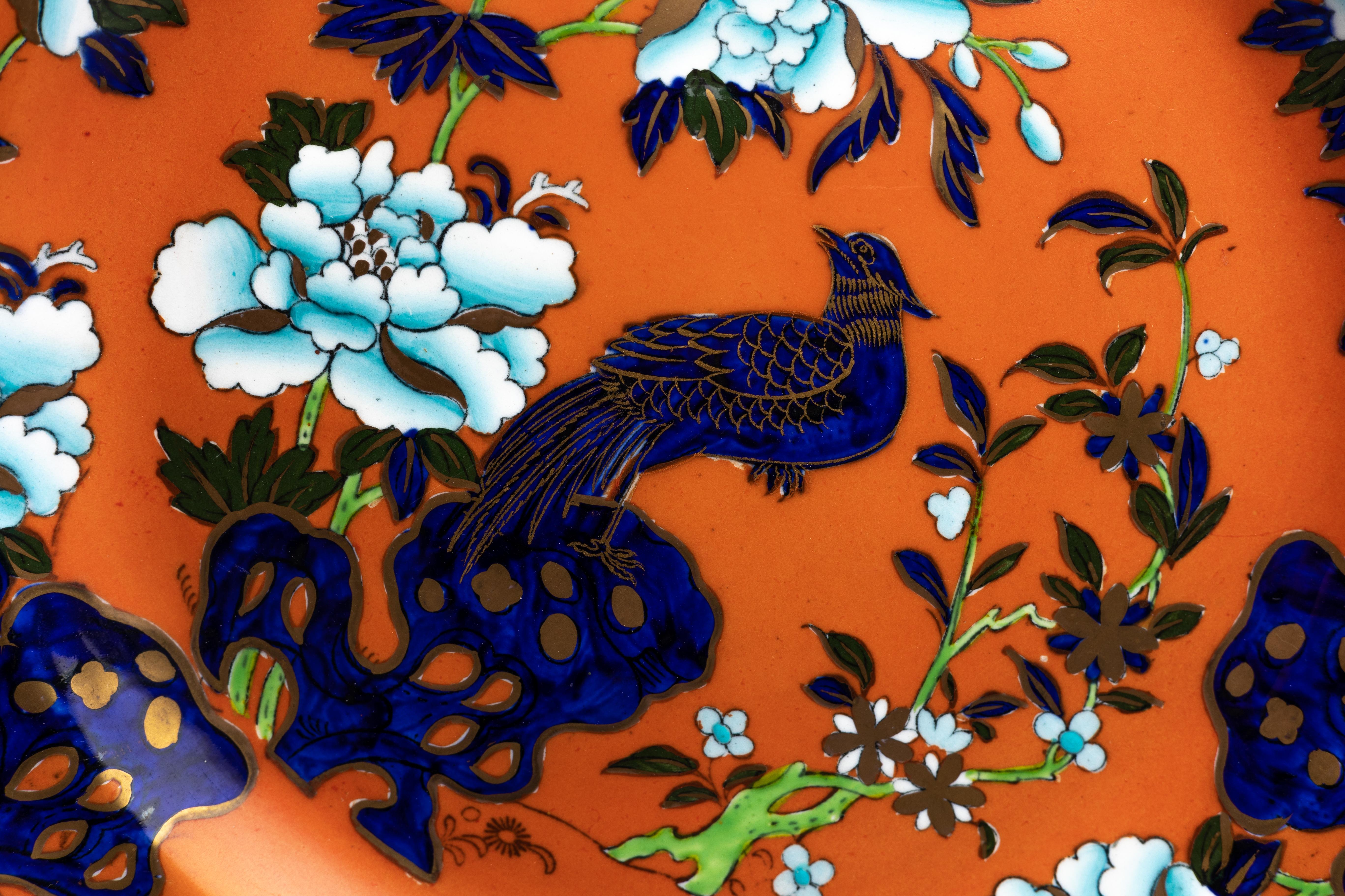 A Masons Ashworth ironstone dinner plate in the ‘Pheasant’ pattern on a striking orange glaze, made in England ca. 1910.

Filled with chinoiserie imagery, the Masons Ashworth ironstone dinner plate makes a bold statement with a striking orange