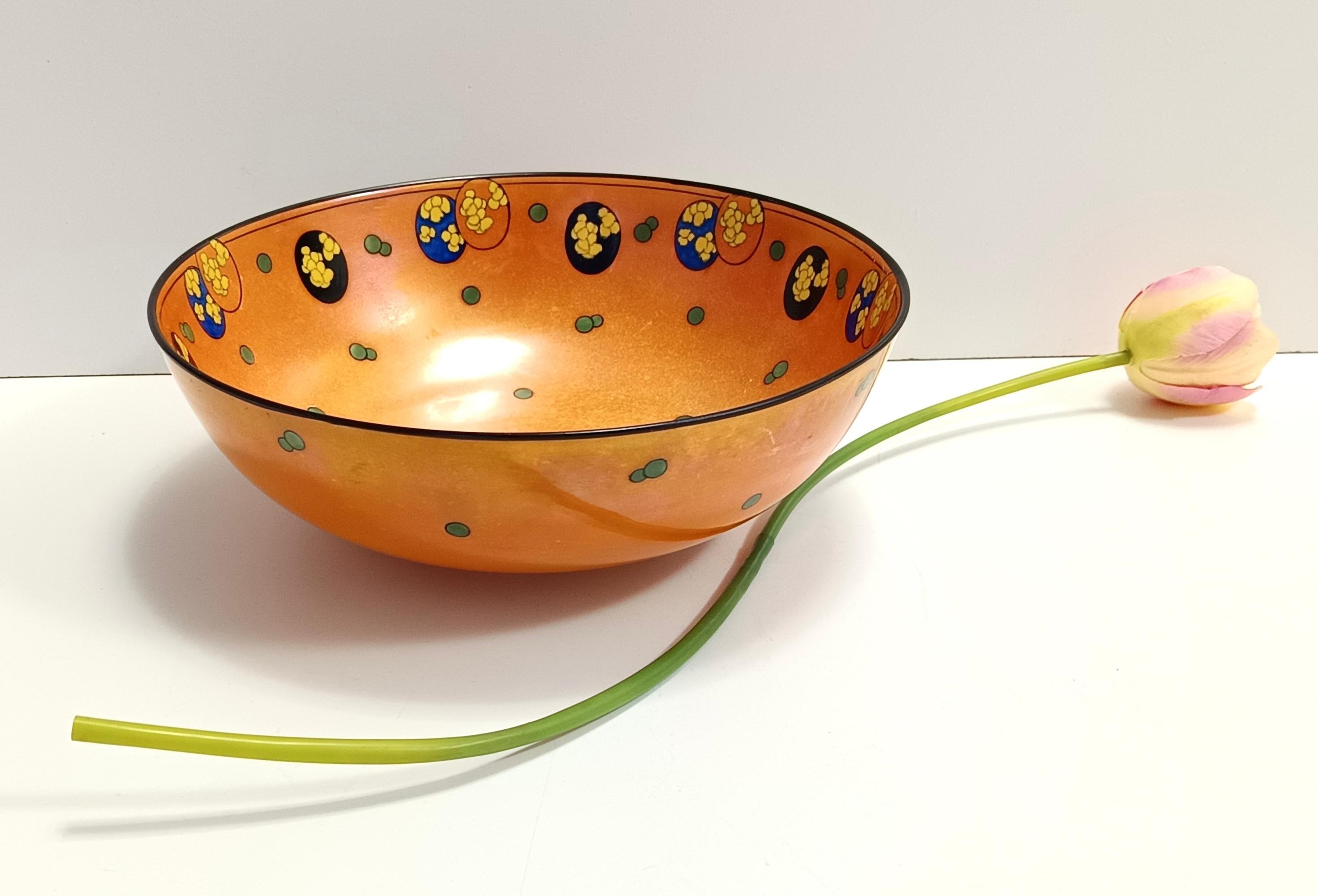 Made in England in 1920s.
It is made in orange iridescent lacquered porcelain with decorations. 
This bowl - vide poche is vintage, therefore it might show slight traces of use, but it can be considered as in excellent original condition. 
It is