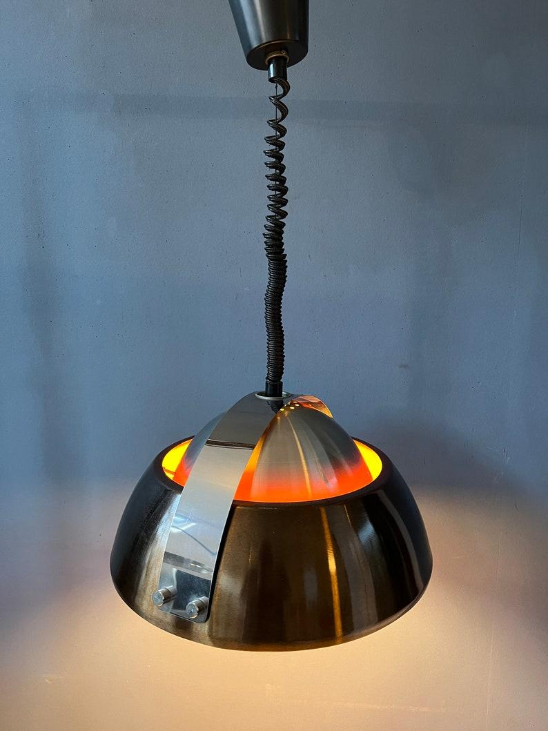 Large orange space age pendant light by Lakro Amstelveen. The lamp is made out of steel and has orange lacquer on the inside. The height of the lamp can easily be adjusted with the rise-and-fall mechanism. The lamp requires one E27 (standard)