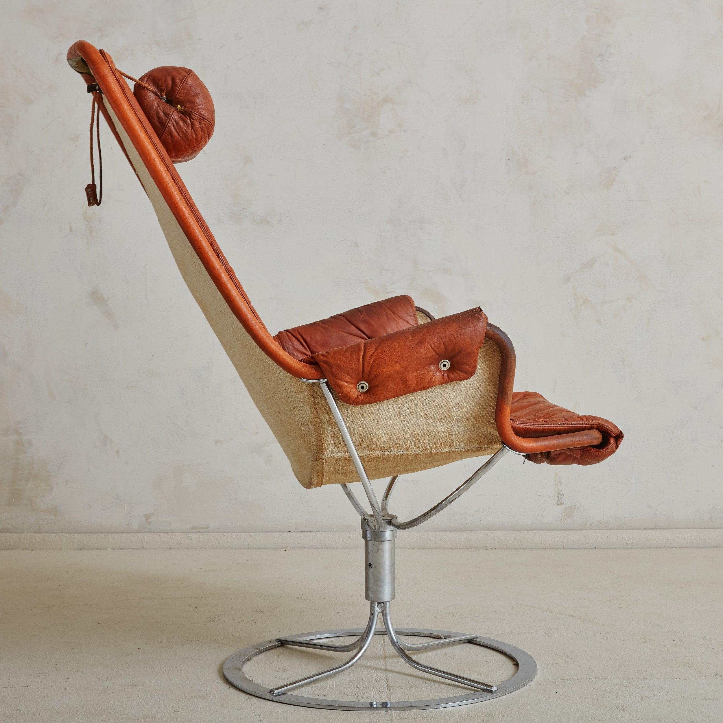 Fauteuil de salon pivotant en chrome et en cuir de l'ère Space AGE, créé par Bruno Mathsson pour DUX dans les années 1970. Reposant sur un socle rond chromé, l'assise en bandoulière élégamment incurvée est dotée d'un revêtement en cuir orange brûlé