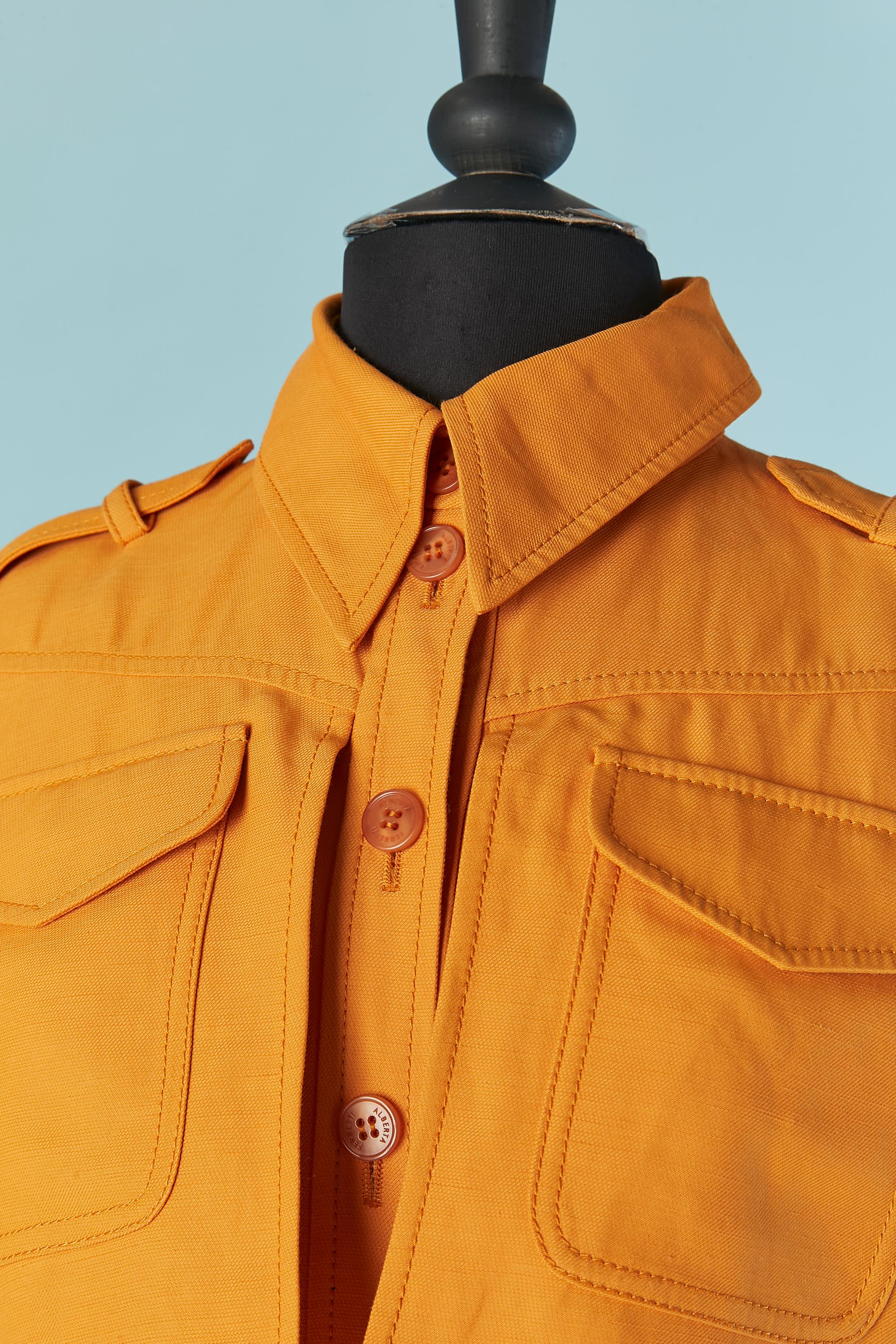 Orange linen and rayon jumpsuit with pockets. Fabric composition: 85% rayon, 15% linen. Branded button and buttonhole closure on the middle front, cuffs and pockets + one extra button provided. The top pocket are on a flap ( a bit like a